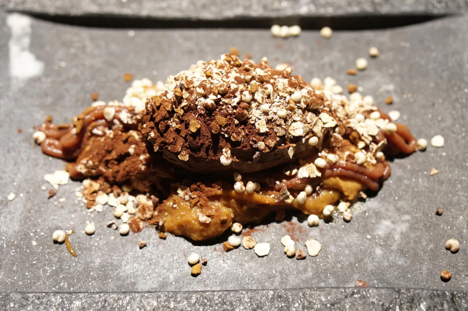 Cremoso de chocolate con plátano y cacahuete สำหรับขนมหวานเราเลือกทานเป็นครีมช็อกโกแลตที่ทำออกมาคล้ายมูส มีรสขมเบาๆ เสิร์ฟมาซอสถั่วลิสงผสมกับกล้วยรสหวานตัดคบ้ายคาราเมล ข้างบนคือผงช็อกโกแลตและธัญพืชเพิ่มมิติทางเนื้อสัมผัส (12/20)