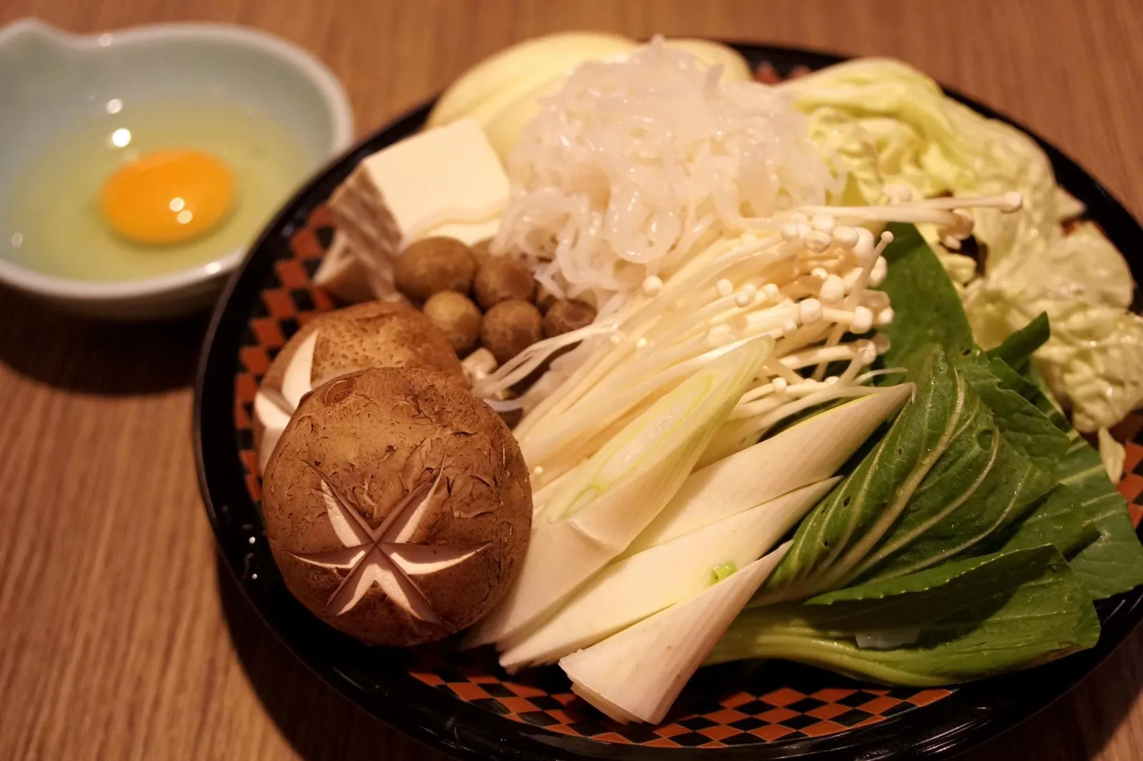 Sukiyaki Thinly sliced meat and vegetables, cooked table side in a sukiyaki hot pot เสิร์ฟกับผักเคียงสดๆและเห็ดญี่ปุ่น มีไข่ดิบเพื่อจุ่มเนื้อก่อนนำไปลวกในหม้อไฟ (10/20)