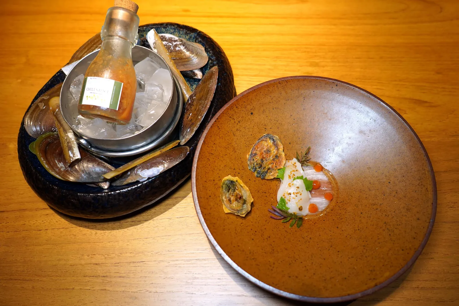 WAY BACK HOMEHIN KGAM CLAMS | RAZOR CLAMS | THAI MUSSELS | THAI OYSTER | JICAMA | GREEN PAPAYA | RHUBARB | SEABITE LEAVES | RED CHILLI PEPPER | GRAPE SKINS | DISTILLED SPIRIT | SAKUNA ROSE WINEเชฟอาศัยแรงบันดาลใจมาจากร้านหอยทอดร้านโปรดแต่นำเสนอมาในรูปแบบเย็น เชฟนำหอยหินงามและหอยหลอดไป Brine แล้ว Poached ต่อในน้ำสต๊อกปลาก่อนจะเตรียมมาเป็น Ceviche ด้านล่างคือผักดองประกอบไปด้วยมันแกวและรูบาร์บจากโครงการหลวง ยังมีมะละกอดิบที่ผ่านการดองกับเหล้าเปลือกองุ่นจากเขาใหญ่ อีกฝั่งหนึ่งคือแผ่นเซมเบ้หอยทอดที่เตรียมมาจากหอยแมลงภู่และแป้งหอยทอด (13/20)