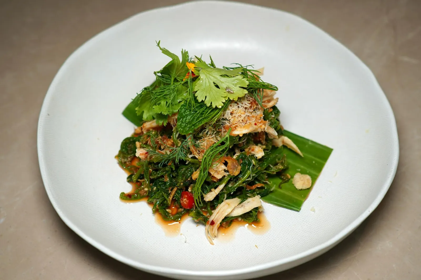 ยำผักกูดไก่ฉีก Fiddlehead fern salad, poached shredded free-range chicken, chili paste, shallots and roasted coconut เชฟนำเนื้อไก่ฉีกเป็นเส้นแล้ว Poached จนสุกพอดี จากนั้นนำไปยำกับน้ำพริกเผา หอมแดง และมะพร้าวคั่วจนได้รสชาติเปรี้ยวหวานเค็มเผ็ดครบรส (13/20)