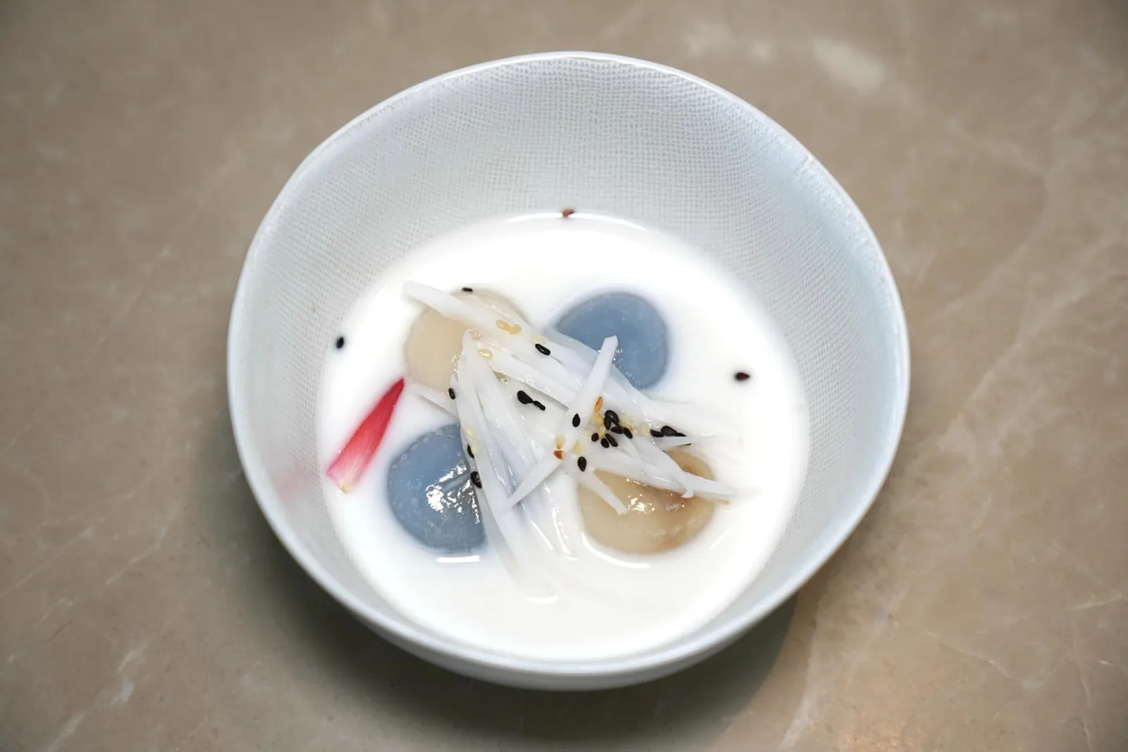 ขนมโคน้ำกะทิ Sticky rice flour and palm sugar dumplings in sweet coconut milk and sesame seeds สำหรับของหวานขึ้นชื่อจากภาคใต้แน่นอนว่าคงหนีไม่พ้นขนมโคที่มีบักษณะเป็นแป้งนุ่มหนึบ ด้านในสอดไส้น้ำตาลมะพร้าวกรอบสู้ฟันให้ความหวานที่แสนกลมกล่อมเข้ากันกับน้ำกะทิด้านนอก ยังมีองค์ประกอบของเนื้อมะพร้าวขูด, งาขาว และงาดำลงไปช่วยเพิ่มกลิ่นหอมให้กับจานได้อีกด้วย (14/20)