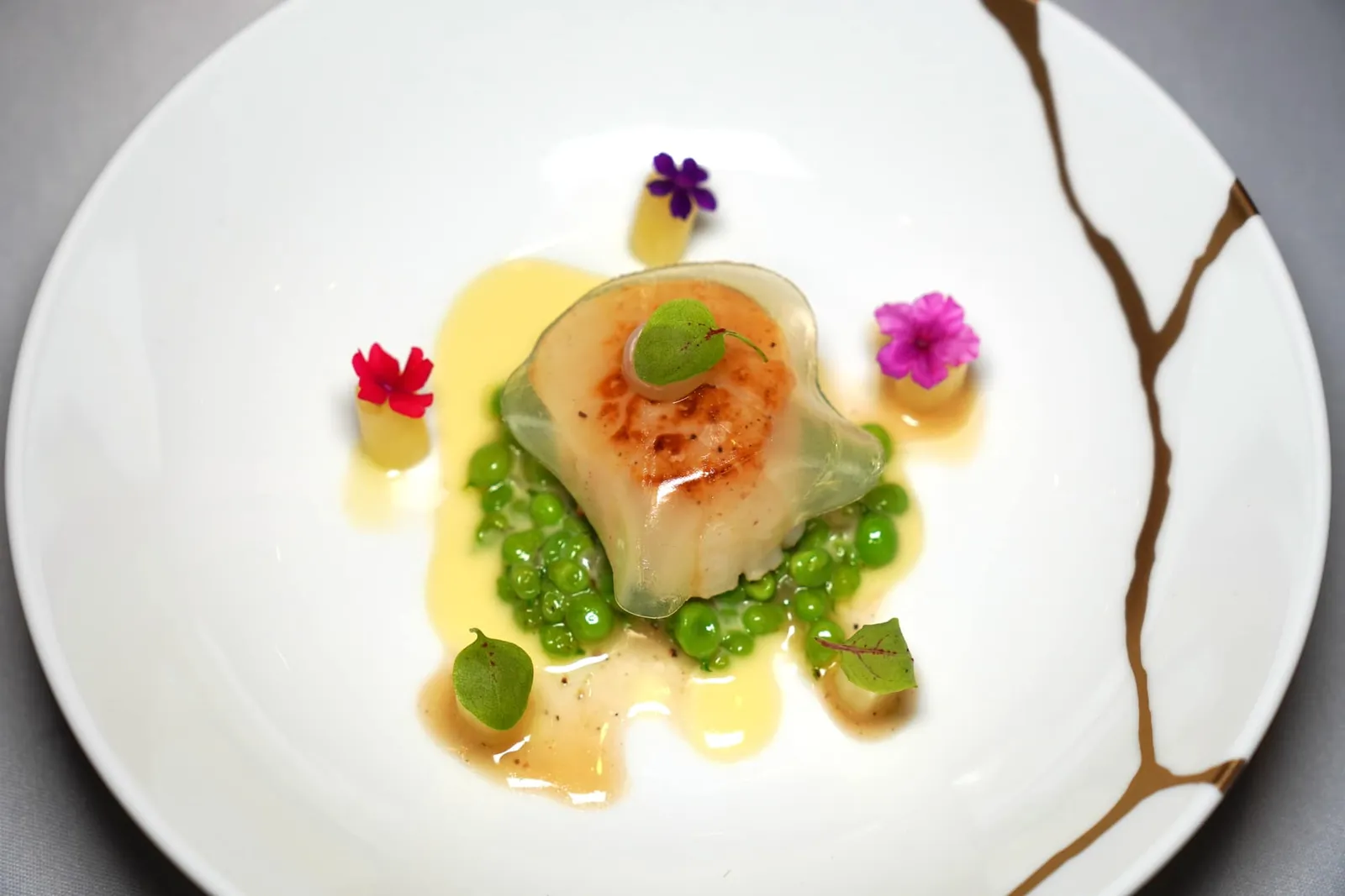 SCALLOP Yuzu Jelly | Sweet & Sour Lotus Upper Roots | Snap Pea | Yuzu Beurre Blanc หอยเชลล์ยักษ์นำเข้าจากแถบทะเลเหนือจี่บนกระทะมาอย่างดี ด้านล่างรองด้วยถั่วสแนปพีเสริมรสชาติหวานและซอสยูซูเบลอบล็องให้รสชาติออกเปรี้ยว ด้านบนคือแผ่นเจลลี่นุ่ม ๆ ที่มีความเปรี้ยวแบบซิตรัสของยูซู สุดท้ายคือองค์ประกอบของไหลบัวเปรี้ยวหวานตกแต่งด้วยดอกไม้รับประทานได้นั่นเอง (15/20)