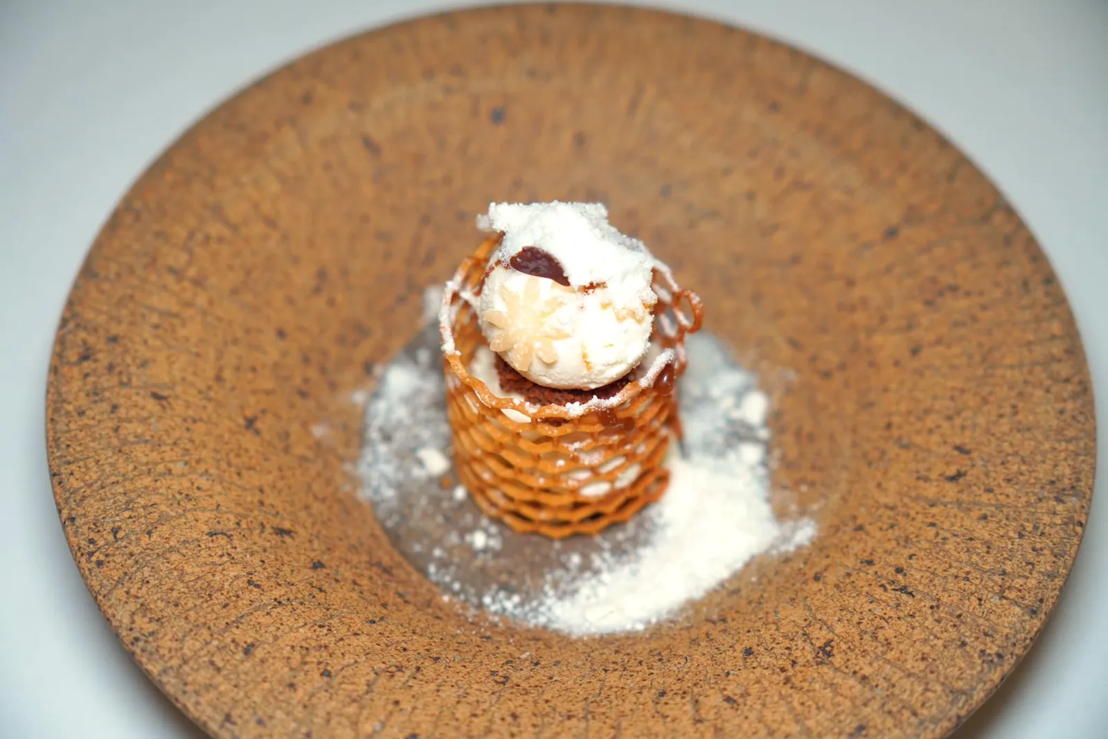 MAIN DESSERT Smoked Milk Ice Cream | Egg Cake ของหวานจานหลักเชฟป็อบนำเสนอ ”ไอศกรีมนมสด“ จากฟาร์มสหกรณ์โคนมบ้านบึง จังหวัดชลบุรี นำมาผ่านกระบวนการพาสเจอร์ไรซ์ก่อนจะนำไปรมควันจนมีกลิ่นควันฝังอยู่ในไอศกรีม ด้านนอกมีความกรอบที่ได้จากแผ่น Tuile น้ำผึ้ง รอบ ๆ คือผงที่เตรียมมาจากนมเช่นกัน (15/20)