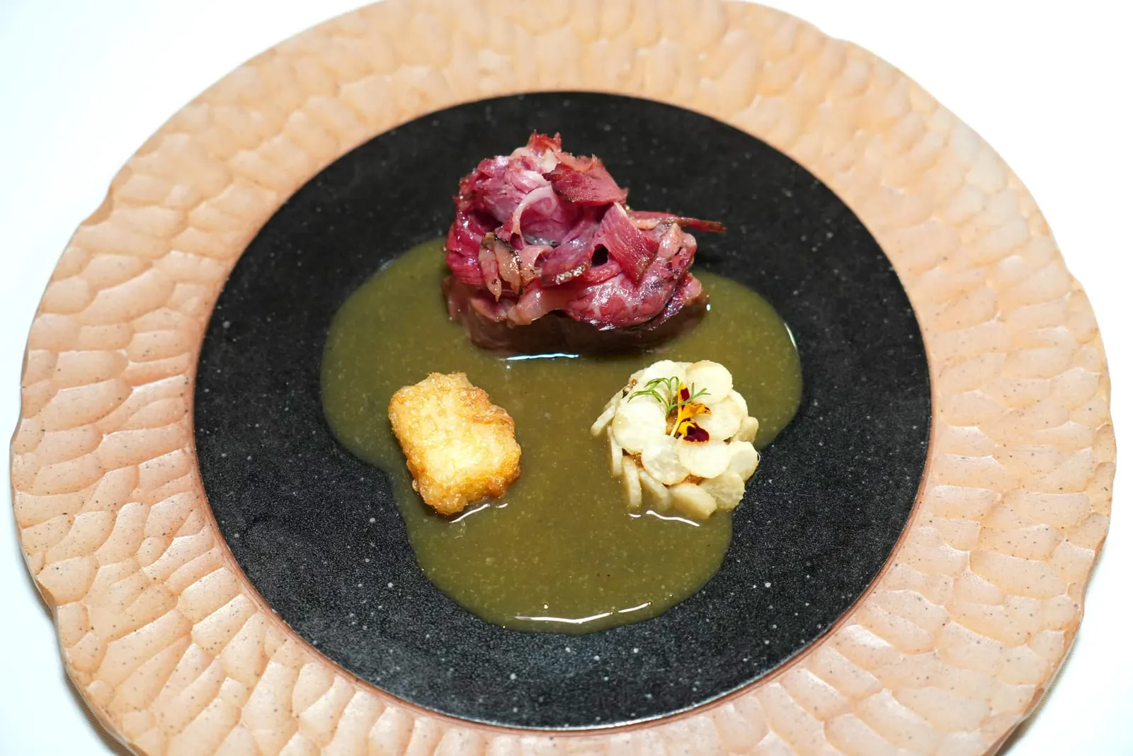 THAI WAGYU Bamboo shoots | Yum Beans | Khao Tod | Bai yanang sauce ”ซั่วเนื้อ” ประกอบขึ้นจากเนื้อวัวไทยวากิวเสิร์ฟมา 2 ส่วนคือสันในที่ผ่านการจี่บนกระทะและส่วนเนื้อซี่โครงที่ผ่านการหมักและรทควันจนคล้ายกับแฮมหรือเบคอน ฟเสิร์ฟมาคู่กันกับมันแกวกรอบที่ผ่านการดองในน้ำยำใส ตรงกลางคือซุบหน่อไม้ ข้าง ๆ คือข้าวทอดให้ความกรอบนอกหนึบใน จากนั้นพนักงานจะเทราดซอสใบย่านางเข้มข้นลงไป (13/20)