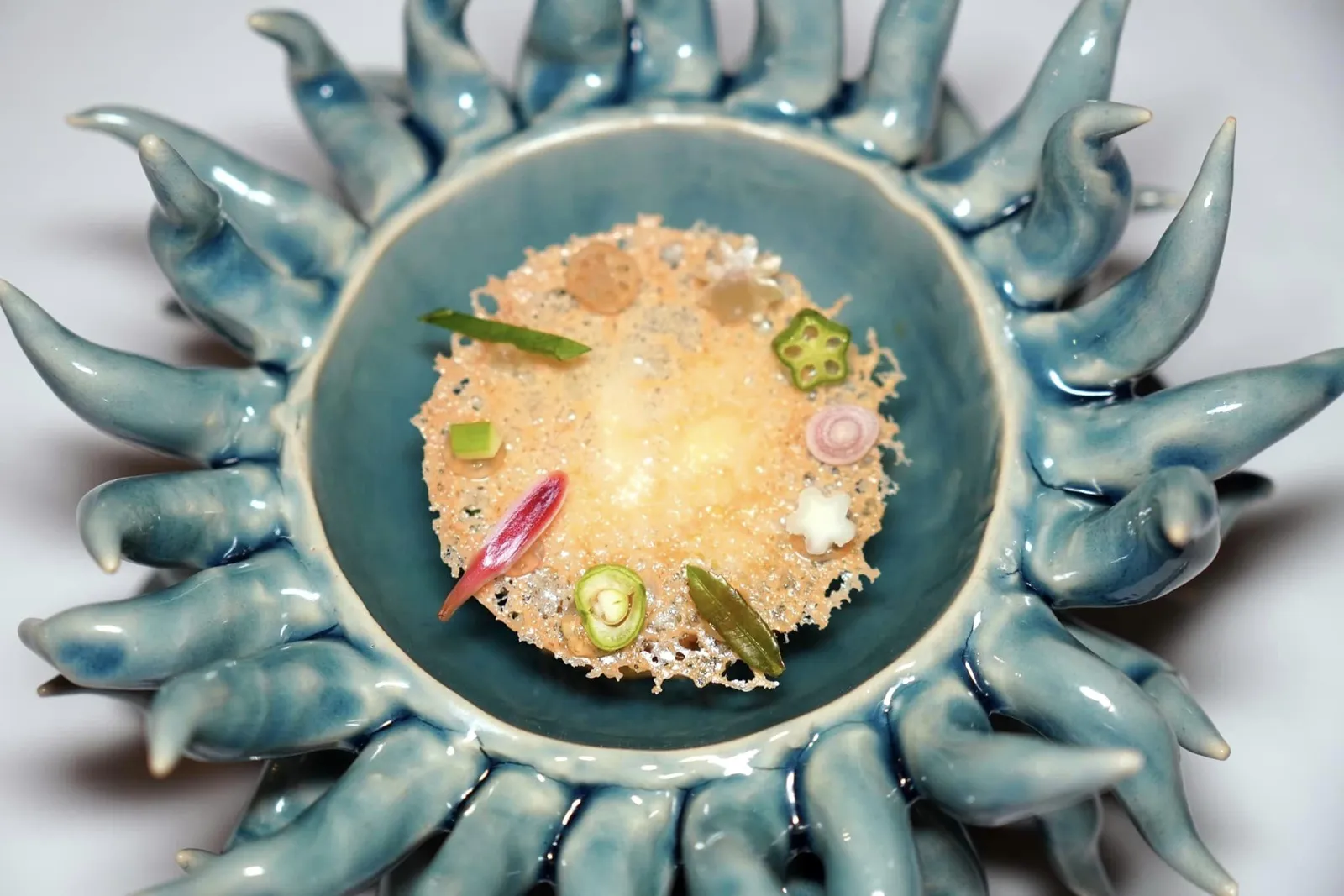 BLUE CRAB Thai Mackerel | Herbs | Curry Paste Rice | Southern Bu-Do Sauce คอร์สนี้เชฟป็อบได้รับแรงบันดาลใจมาจากคุณยายซึ่งเป็นคนจังหวัดนครศรีธรรมราช เชฟนำเสนอเมนู ”ข้าวยำ“ โดยนำข้าวหอมมะลิจากจังหวัดยโสธรไปคลุกกับเครื่องแกงใต้ นอกจากนี้ยังมีองค์ประกอบของน้ำบูดูโฮมเมด สมุนไพร และผัดสดต่าง ๆ รวมกันถึง 12 ชนิดอย่างเช่นดอกดาหลา ใบพาโหม ใบไชยา นอกจากนี้ยังมีความหวานที่ได้จากปูม้าและความเค็มอันกลมกล่อมของปลาทูอีกด้วย (14/20)
