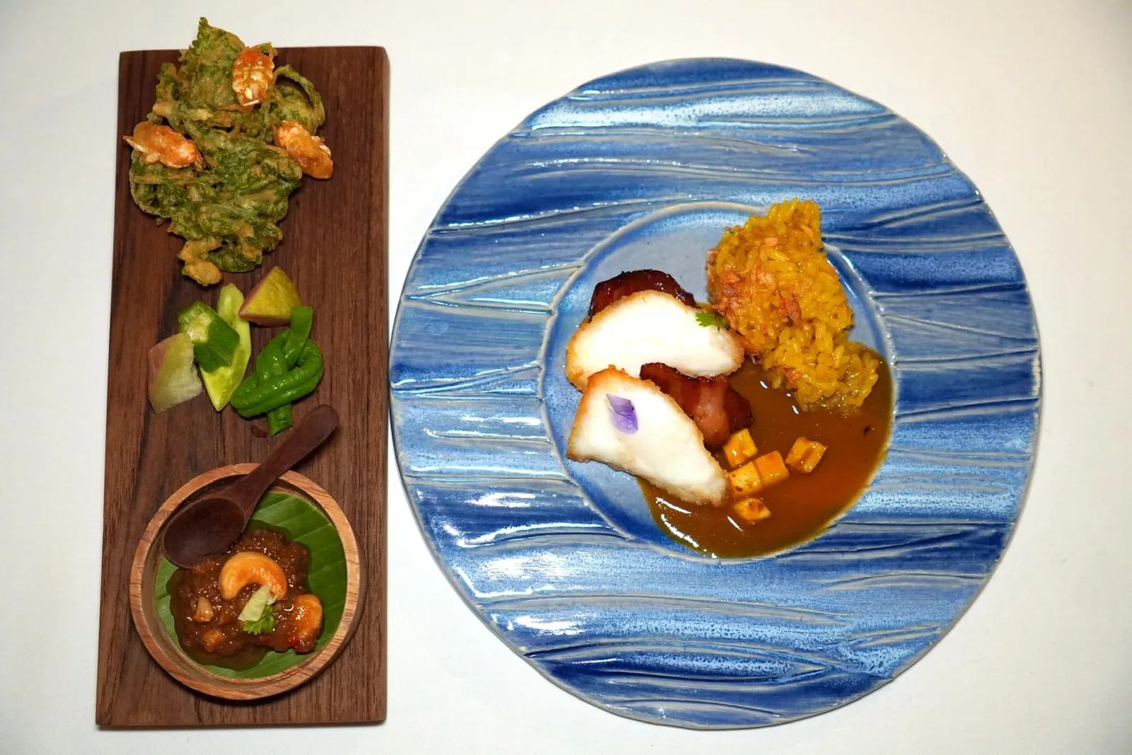 CORAL TROUT Cashew nut | Dried Shrimp | Herbs Pork neck | Pineapple | Southern Yellow Curry Yellow Steamed Ou-Doi Rice ปลากะรังจุดฟ้าที่ผ่านการจี่บนกระทะเสิร์ฟมาคู่กันกับซอส ”แกงเหลืองสับปะรดภูแล“ สูตรทางใต้ เชฟเพิ่มมิติทางรสชาติด้วยการใส่คอหมูหวานเนื้อนุ่มฉ่ำวางลงไปสลับกันกับชิ้นปลา นอกจากนี้ ยังมีความกรอบที่ได้จากสับปะรดหั่นเต๋า เชฟแนะนำให้รัยประทานกับข้าวหมกที่เตรียมมาจากข้าวอูดอยจากภาคเหนือ ข้าง ๆ คือกันคือ ”น้ำพริกหัวครก” รสชาติจัดจ้านจับคู่มากับผักและผลไม้เคียง นอกจากนี้ยังมีใบผักกูดทอดเสิร์ฟมาคู่กันกับจักจั่นทะเลที่ทอดมาได้อย่างพอดิบพอดีคือมีความกรอบ เคี้ยวง่าย และไม่อมน้ำมัน (15/20)
