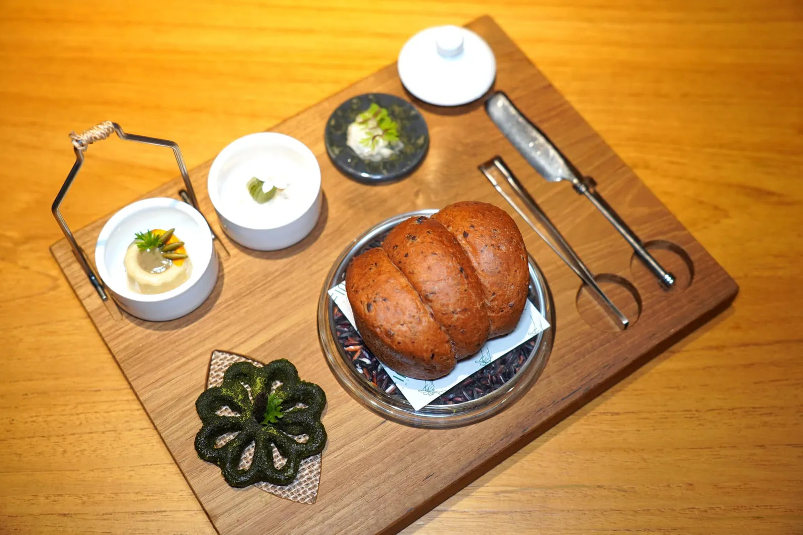 PINTOKUM DOI RICE FROM CHIANG MAI | PUMPKIN PELL | PUMPKIN SEED PRALINE | CARAMELIZED WILD HONEY | BETONG CHICKEN | BURNT LEEK | CABBAGE | CORN SPROUTSปิ่นโตเตรียมมาโดยอาศัยแรงบันดาลใจในวัยเด็กแต่เปลี่ยนรูปแบบมานำเสนอในลักษณะของขนมปังโฮมเมด เชฟแนะนำให้เริ่มต้นด้วยแผ่นแครกเกอร์ที่เตรียมมาจากเปลือกฟักทอง ด้านในสอดไส้ด้วยฟักทองพูเรและเบซิลชวนนึกถึงเมนูฟักทองผัดไข่ (14/20)