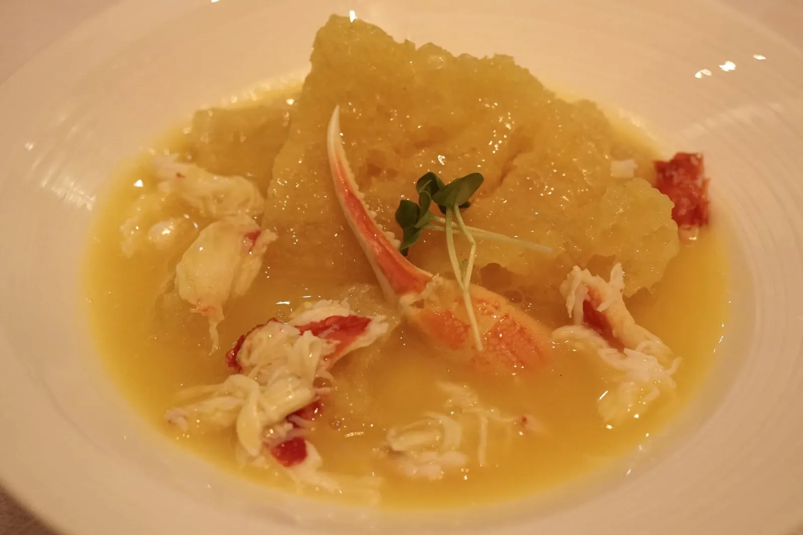 Stewed fish maw with crab claw in supreme chicken broth (1,180 MOP) 🐟 เริ่มต้นโดยการนำน้ำซุปไก่ (แบบเดียวกันกับซุปหอยจานถัดไป) มา Double boiled นานกว่า 8 ชั่วโมง ต่อมาใส่แครอท และหอยเชลล์ไป เคี่ยวต่ออีกเป็นเวลานานกว่า 4 ชั่วโมงจนได้น้ำซุปไก่เข้มข้น สีเหลืองทองในระดับ “Supreme chicken broth” ต่อมาใส่กระเพาะปลาเกรดพรีเมี่ยมชิ้นโตที่คัดสรรค์มาอย่างดีลงไป ตัวกระเพาะปลาจะทำหน้าที่คล้ายฟองน้ำโดยการดูดน้ำซุปไก่แทรกเข้าไปจนมีเนื้อสัมผัสนุ่มฉ่ำ มีกลิ่นหอม ปิดท้ายด้วยการวางเนื้อปูและก้ามปูลงไปเพื่อเพิ่มมิติทางรสชาติ จัดเป็นสุดยอดเมนูอาหารชาววังที่ยังหลงเหลือให้ทานเพียงไม่กี่แห่งบนโลก สำหรับเรามันคือเมนูกระเพาะปลาที่อร่อยที่สุดเท่าที่เคยทานมา และไม่รู้จะหากระเพาะปลาอร่อยแบบนี้ได้จากที่ไหนเเล้วในชีวิต แม้จะราคาสูงไปหน่อย แต่หากได้เเวะมาทานอาหารที่ร้านนี้แล้วห้ามพลาดด้วยประการทั้งปวง ❤️ (18/20) ปล. หากใครอยากชิมเมนูคล้ายกันนี้ในราคาที่เป็นมิตรมากขึ้น แนะนำเมนู Stewed fish maw with crab meat in chicken broth ในราคา 680 MOP หรือรวมภาษีแล้วราวๆ 3,000 บาท โดยทางร้านจะใส่แต่เพียงเนื้อปู ไม่ได้ใส่ก้ามปูมาให้ ส่วนซุปที่ใช้จะเป็นน้ำซุปไก่ระดับปกติ ไม่ใช่น้ำซุประดับ Supreme ขนาดของกระเพาะปลาเล็กลงเล็กน้อย ขอแนะนำเผื่ออย่างน้อยให้คนที่มีใจรักอาหารจีนได้มาชิมเมนูนี้สักครั้งในชีวิต ดูน้อยลง