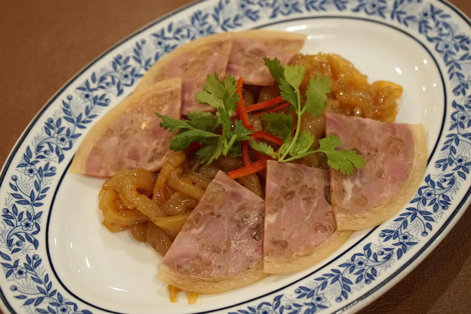 ขาหมูแมงกะพรุนเย็น (180+) Chinese pork leg and cold jelly fish in sesame sauce เมนูอาหารว่างสุดคลาสสิคของภัตตาคารจีน แต่โดยปกติแล้วร้านอาหารทั่วไปจะล้างแมงกระพรุนเเล้วยังเหลือกลิ่นเกลือและรสเค็มของทะเลไว้มากทำให้คนไทยหลายกลุ่มไม่ชอบทานแมงกระพรุนเย็น แต่ของที่นี่ทำออกมาได้ดีมาก ตัวเเมงกระพรุนคุณภาพสูง นำเข้าจากฮ่องกง คัดเฉพาะส่วนโดมของเเมงกะพรุนมาใช้ ทำให้มีเนื้อสัมผัสที่ดี เคี้ยวหนึบ ไร้ซึ่งกลิ่นคาว ราดด้วยซอสน้ำมันงา ตัดกับขาหมูเย็นยัดไส้แฮม มีกลิ่นหอม จัดว่าอร่อยกว่าร้านอาหารจีนในฮ่องกงที่เคยไปทานหลายๆร้านเสียอีก (14/20)