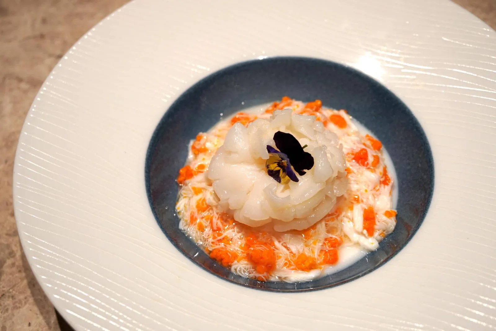 珊瑚芙蓉蝦球皇 (420 HKD) Steamed king prawn with egg white and crab coral สุดยอดเมนูซิกเนเจอร์ประจำร้าน และเป็นผลงานชิ้นเอกที่รวบรวมทั้งรสชาติ ความคิดสร้างสรรค์ และศิลปะเข้าไว้ด้วยกัน กุ้งขนาดกลางถูกจัดวางมาเป็นวงคล้ายดอกไม้ มีขนาดพอดีคำ เนื้อสัมผัสนุ่ม เด้ง สุกกำลังดี รองด้านล่างด้วยไข่ขาวเนื้อละมุน และเนื้อปูฉีกเป็นเส้นฝอยสวยงาม ตัดเลี่ยนเเละเสริมกลิ่นหอมด้วยไข่ปูสีส้มสดตัดกับสีของไข่ขาวและกุ้ง ทอปด้านบนด้วยดอกไม้ทานได้สีม่วง เหมาะกับผู้ที่หลงไหลในรสธรรมชาติของสุดยอดวัตถุดิบแห่งท้องทะเล (17/20)