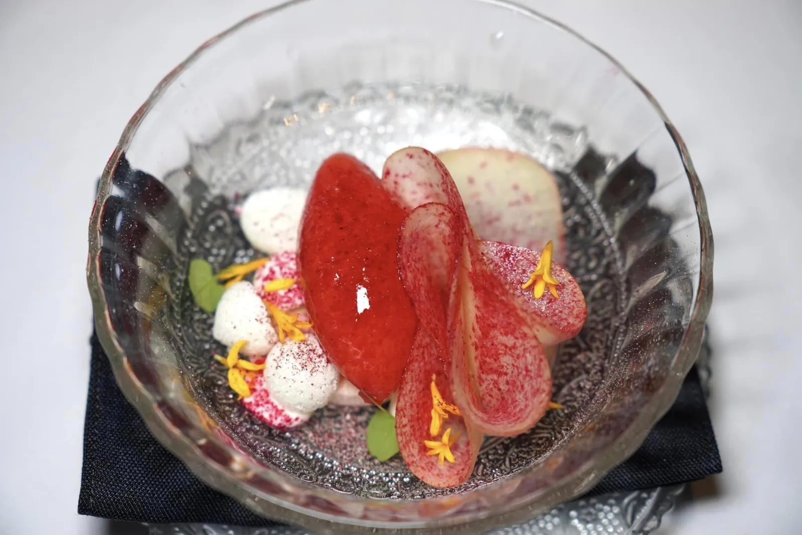 Freshly Shaven Apple Fermented Kantan and Strawberry Sorbet, Red Pepper Marshmallow, Chantilly Cream, Sour Plum Powder ปิดท้ายมื้ออาหารด้วยของหวานที่เชฟนำแอปเปิ้ลแดงไปฝานเป็นชิ้นบาง ๆ ยาว ๆ เคี้ยวแล้วให้ความกรอบที่พอเหมาะจับคู่กับ เมอแรงก์กรอบรวมไปถึง Marshmallow นุ่มหนึบที่เตรียมขึ้นมาจากพริกหวาน นอกจากนี้ยังมีซอร์เบท์ที่ผสมผสาน Bunga Kanta หรือดอกดาหลาที่ผ่านกระบวนการหมักกับผลสตรอว์เบอร์รี่ช่วยเพิ่มความสดชื่น ทุกอย่างเชื่อมด้วยความหอมมันของ Chantilly Cream ได้อย่างลงตัวไร้ที่ติก่อนที่เชฟจะจบด้วยการโรยผงบ๊วยลงไปรอบ ๆ จาน (16/20)