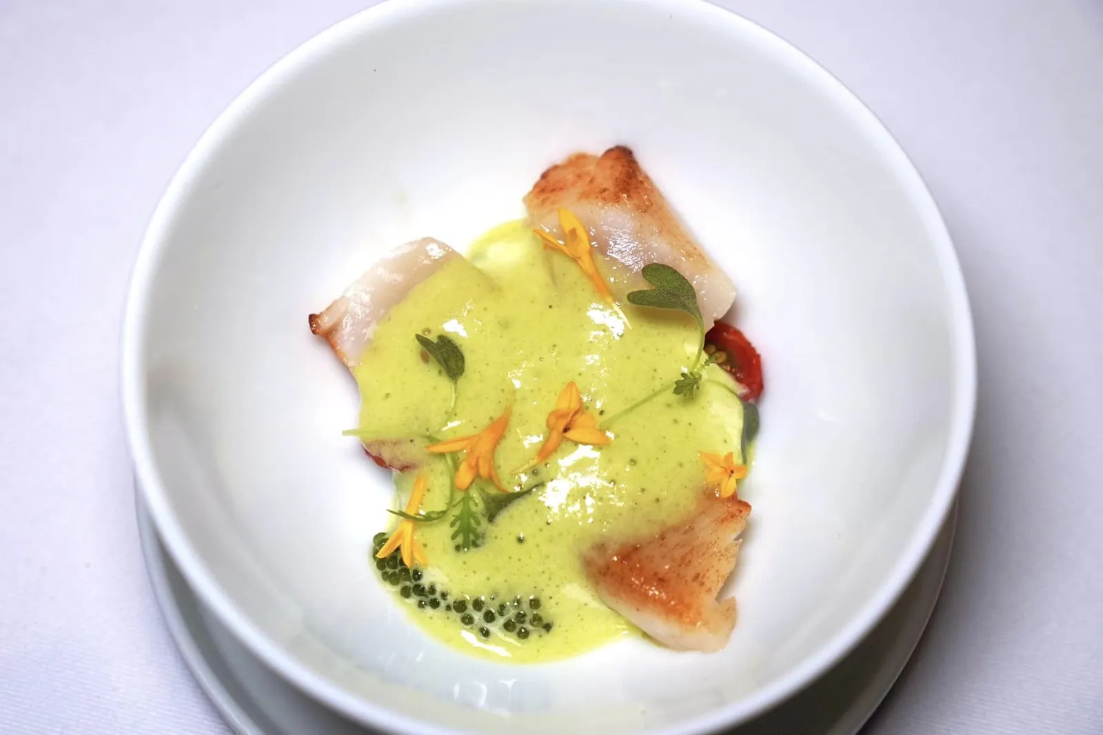 50/50 Tomato Consomme Sweet Basil Oil, Hokkaido Scallops, Petit Pois, Dehydrated Baby Tomatoes, Tomato Bread จานนี้เชฟนำเสนอหอยเชลล์ยักษ์โฮตาเตะจากเกาะฮอกไกโดที่ผ่านการรมควันและจี่จนสุกจับคู่มากับสาหร่ายพวงองุ่นและ Petit Pois หรือชิ้นถั่วขนาดจิ๋ว ด้านล่างมีมะเขือเทศแห้งช่วยเติมความอุมามิ ด้านบนท็อปด้วยน้ำมันเบซิล (15/20)