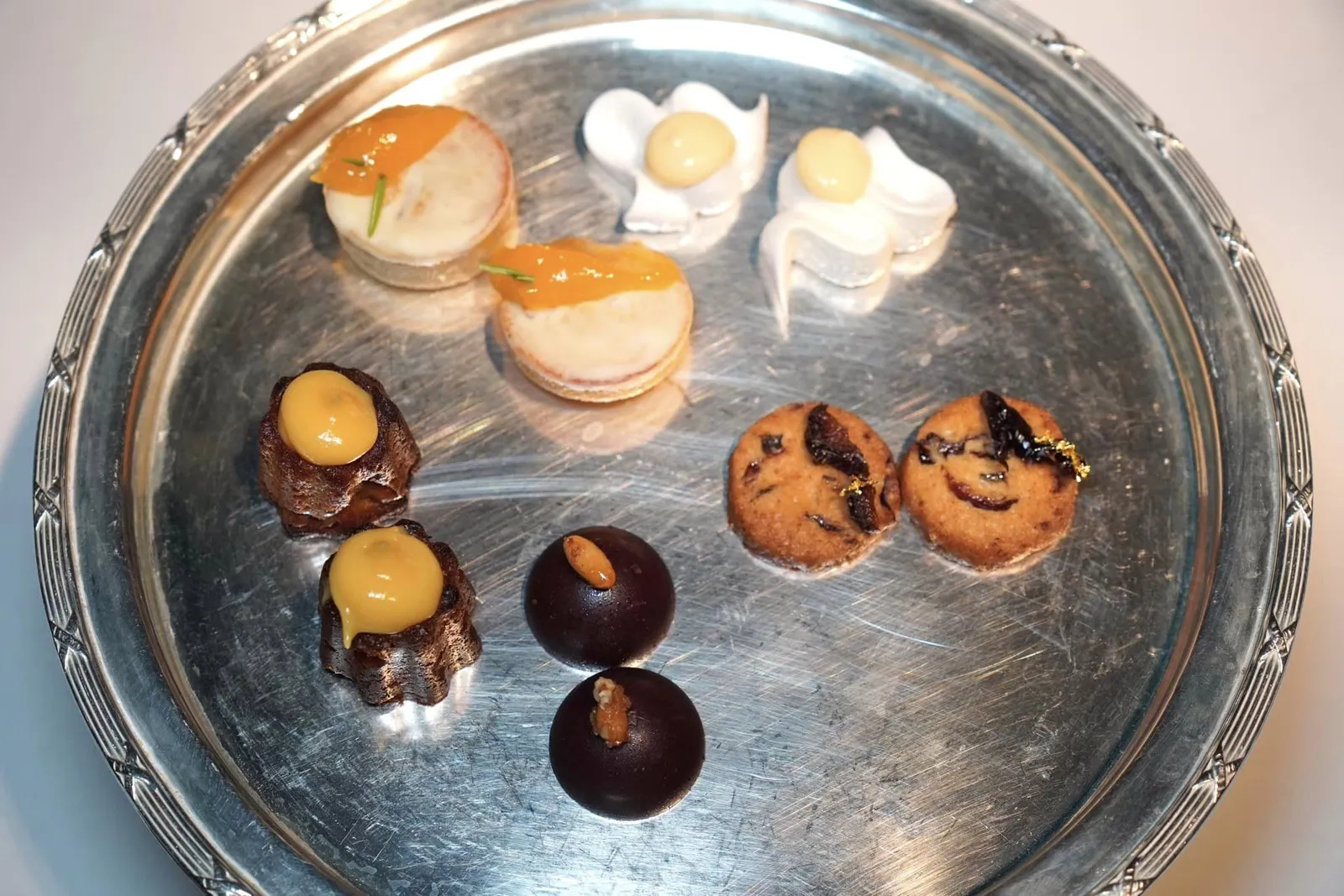 Les mignardises de Dalí ปิดท้ายมื้ออาหารด้วยขนมชิ้นจิ๋วประกอบไปด้วย Chocolate Bonbon with Candy and Pine Nut, Plum Cookies, Dried Meringue with Lemon and Orange, White Chocolate Financier with Apricot and Almonds และ Banana Canelé with Passionfruit