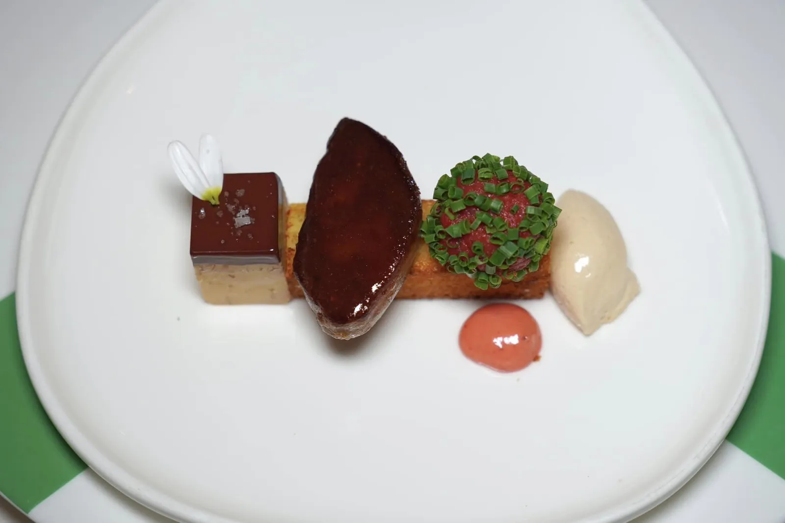 Rico's sandwich of roasted orange - brioche, foie gras with Callebaut - chocolate and beef tartare - praline ขนมปัง Orange Brioche กรอบนอกนุ่มใน องค์ประกอบแรกฝั่งซ้ายมือคือ Foie Gras Terrine หรือเทอร์รีนตับห่านที่เตรียมมาอย่างดีสังเกตจากความเนียนและละมุนที่สัมผัสได้ทันที่ตั้งแต่ขั้นตอนการใช้มีดตัด ด้านบนคือองค์ประกอบของช็อกโกแลตแบรนด์ Callebaut จากประเทศเบลเยี่ยมจับคู่กับรสชาติของเชอร์รี่และเกลือเพียงเล็กน้อย ถัดมาคือตับห่านที่จี่บนกระทะจนสุกได้ที่ให้ความกรอบของผิวนอกเป็นเลเยอร์บาง ๆ ในขณะที่ข้างในให้ความครีมมี่ไร้ที่ติ ถัดมาคือ Beef Tartare สับละเอียดจนเนื้อสัมผัสเนียนละมุนห่อด้วยต้นหอมจีนช่วยแต่งกลิ่นของ Tartare ให้โดดเด่นมากยิ่งขึ้น ฝั่งขวามือสุดคือไอศกรีมตับห่านให้ความหอม มัน และครีมมี่โดยไร้ซึ่งกลิ่นของเหล็กมารบกวนข้อดีอื่น ๆ แม้แต่น้อย (18/20)