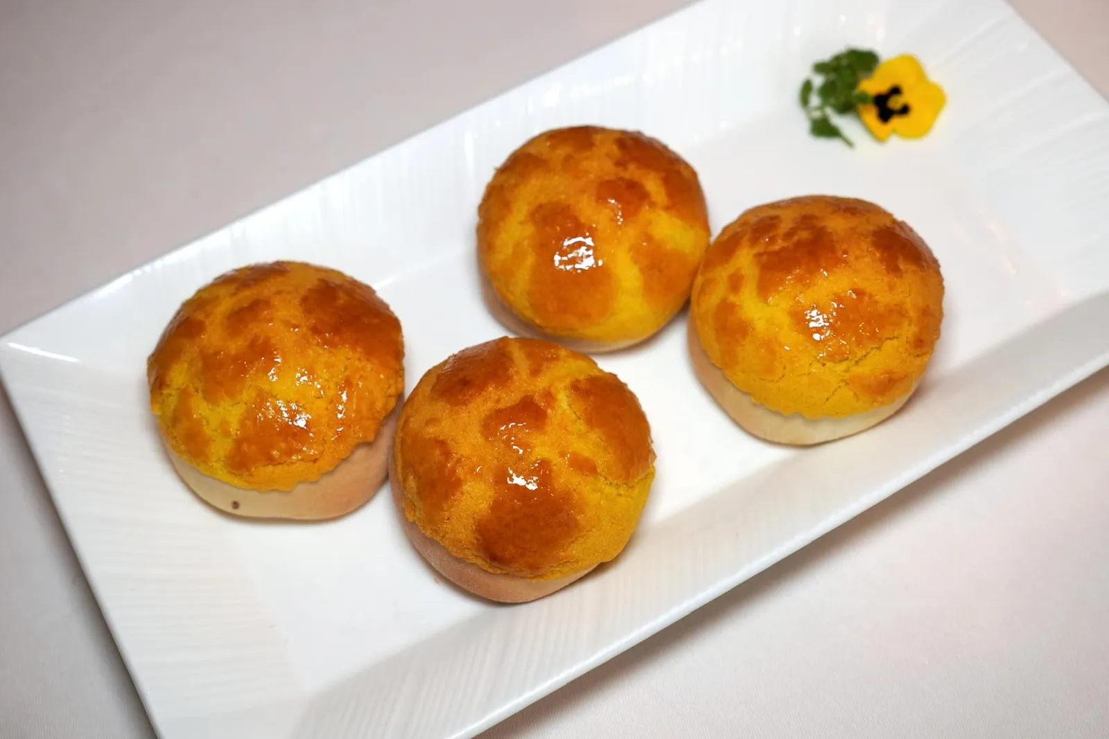 崧子叉燒菠蘿包 (80 HKD+) Baked Barbecued Pork Buns with Pine Nuts อีกหนึ่งเมนู Signature Dim Sum ที่ห้ามพลาดคือซาเปาหมูแดงอบ แป้งซาลาเปากรอบนอกนุ่มใน เพียงเคี้ยวเบา ๆ ก็ละลายในปาก ไส้หมูด้านในนุ่มและปรุงรสมาให้มีความหวานพอเหมาะ นอกจากนี้ยังมีองค์ประกอบของเมล็ดสนช่วยเพิ่มมิติทางเนื้อสัมผัสอีกด้วย สำหรับใครที่ไม่ทราบเราขอแอบเล่าเรื่องให้ฟังว่า Mak Kwai-pui เคยทำงานเป็นเชฟประจำห้องอาหาร Lung King Heen ทั้งยังรับหน้าที่เตรียมเมนูซาลาเปาหมูแดงอบนี้อยู่นานหลายปีก่อนจะลาออกไปเปิดห้องอาหาร Tim Ho Wan เป็นของตัวเองในปี 2009 และรังสรรค์เมนูซาลาเปาอบที่เราคุ้นเคยกันดีโดยอาศัยประสบการณ์ที่เขาเคยเตรียมซาลาเปาอบที่ห้องอาหาร Lung King Heen แห่งนี้นั่นเอง (18/20)