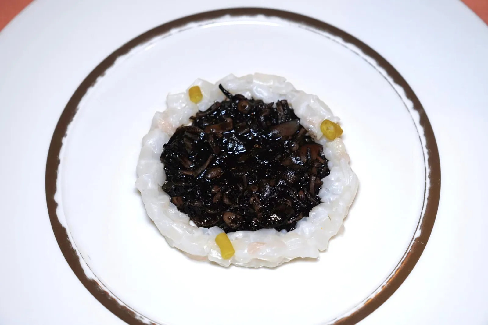 JIG-CAUGHT SQUID STEWED IN THEIR INK WITH IBERIAN AND PEPPER หมึกที่จับจากการตกเบ็ดสับเป็นชิ้น ๆ รายล้อมอยู่วงนอกท็อปด้วยชิ้นพริกหวานดองที่เรียกว่า Piparras ตรงกลางคือเนื้อส่วนของเท้าหมูดำไอบีเรียที่คลุกเคล้ากับดีหมึกและพริกไทยจนเข้ากัน ทั้งยังให้อโรมาหอมและเนื้อสัมผัสที่แตกต่างกับหมึกที่อยู่วงนอกได้อย่างลงตัว (17/20)