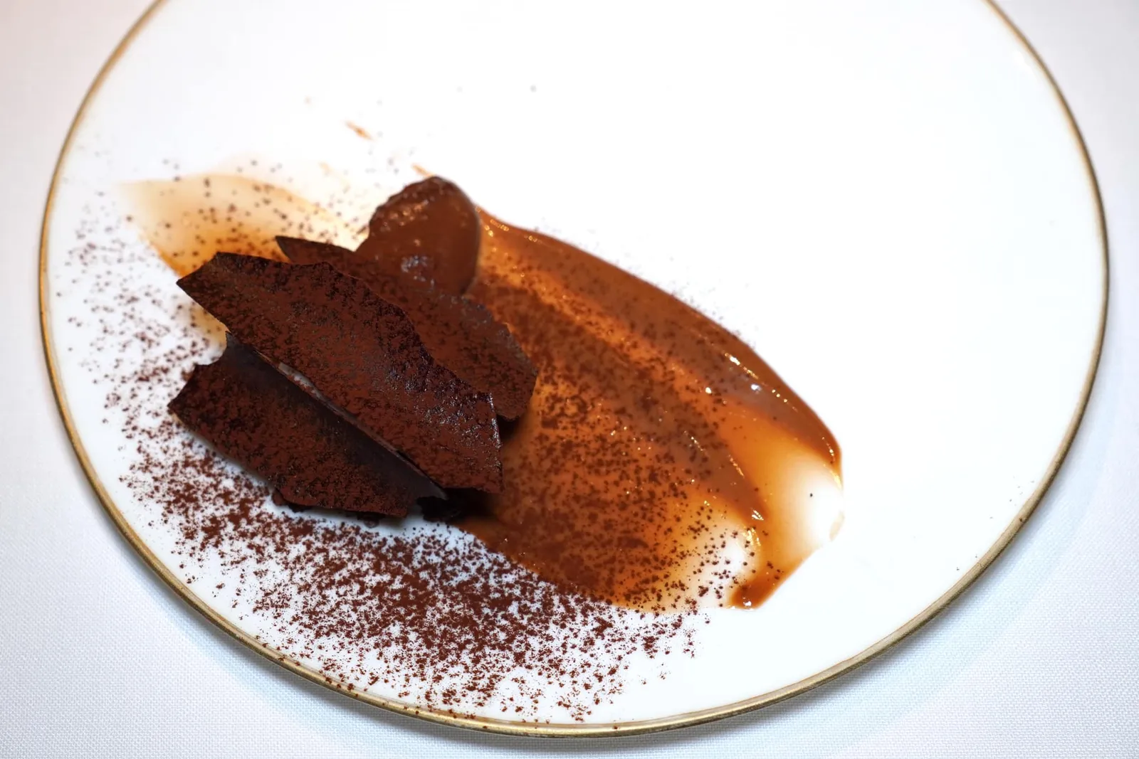 THE COCOA AGE. Cacao Barry จานนี้เชฟตั้งใจนำเสนอช็อกโกแลตมาในหลากหลายรูปแบบที่แตกต่างตามแต่ละช่วงอายุทั้งช็อกโกแลตมูส ช็อกโกแลตกับถั่วฮาเซลนัท ช็อกโกแลตกับกาแฟ ไอศกรีมฝักช็อกโกแลต และองค์ประกอบจากเมล็ดโกโก้รองอยู่ที่ฐานด้านล่าง (20/20)