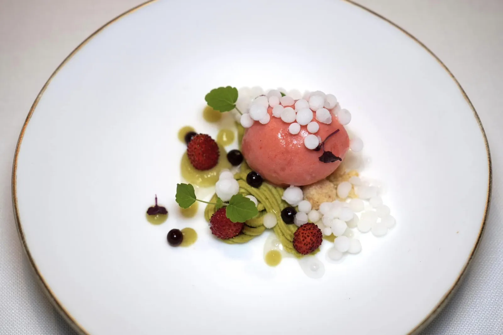WILD STRAWBERRIES, BASIL AND AGED VINEGAR. Spring ของหวานจานนี้คือผลสตรอว์เบอร์รี่ป่าเสิร์ฟมาทั้งผลสด ๆ และไอศกรีม ด้านล่างรองด้วยครัมเบิ้ลกรอบ ยังมีครีมสีเขียวที่มีอโรมาของโหระพาฝรั่งและสมุนไพร ด้านบนคือไข่มุกกลม ๆ รสเปรี้ยวที่เชฟเตรียมขึ้นมาจากมะนาว หยดสีดำเตรียมมาจากน้ำสมสายชูบ่มให้ความเปรี้ยวหวาน จานนี้จัดเป็นของหวานที่มีความซับซ้อนและยังคงรสชาติที่เข้าถึงง่ายและเรียกความสดชื่นได้ดีมาก ๆ (20/20)