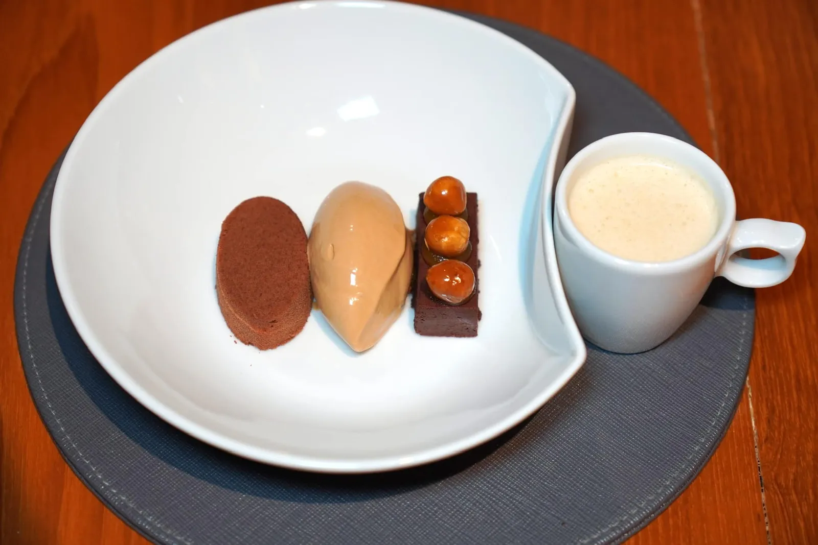 Chocolate Ganache (350++) Hazelnut, White Chocolate Soy Ice Cream, Brownie, Passion Fruit ของหวานที่เราชอบมาก ๆ คือช็อกโกแลตกานาซ ตรงกลางคือไอศกรีมที่ผสมผสานถั่วเหลืองเข้ากันกับไวท์ช็อกโกแลต อีกฝั่งหนึ่งคือเค้กบราวนี่ท็อปด้านบนด้วยถั่วฮาเซลนัทพร้อมกับความเปรี้ยวที่ได้จากเสาวรส พนักงานแนะนำให้ดื่มนมถั่วฮาเซลนัทอุ่น ๆ ตามกันไปได้เลย (15/20)