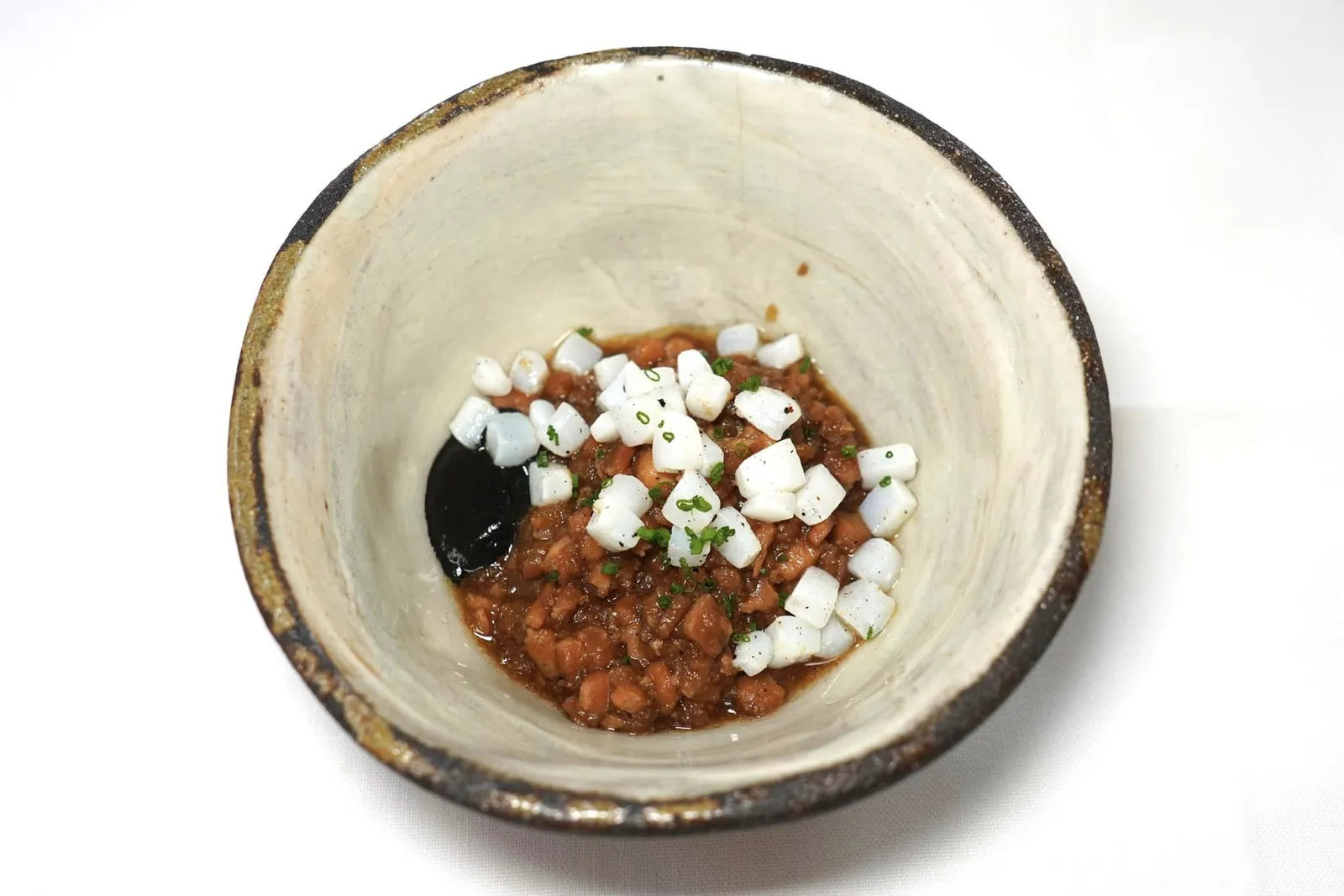 Guiso de “Begihaundi” (19 €) Marin stew of squid “Begihaundi” สตูว์สูตรพิเศษที่นำเสนอหมึกออกมาใน 3 รูปแบบ อย่างแรกคือที่หมึกที่ผ่านการหั่นเป็นชิ้น ๆ แล้วนำไปตุ๋นกับหัวหอมที่หั่นด้วยมือจนได้ชิ้นเล็กจิ๋วในความร้อนต่ำนานถึง 6 ชั่วโมงครึ่งจนนุ่มละทุน ด้านบนคือเนื้อหมึกย่างหั่นเป็นชิ้นเต๋าเคี้ยวหนึบตัดเนื้อสัมผัสกันกับสตูว์ได้อย่างลงตัว สุดท้ายคือดีหมึกช่วยเพิ่มความหอมให้กับจานนี้ได้อย่างไร้ที่ติ (17/20)
