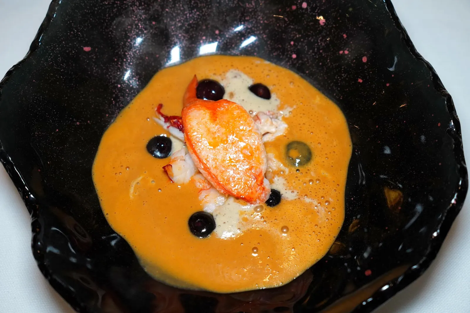 CIVET DE HOMARD DORÉ AU SAUTOIR, Myrtilles de Magescq, Jus de Presse au Jerez. จากนั้นพนักงานจะเทราดซุปครีมล็อบสเตอร์ที่มีส่วนผสมของ Jerez หรือไวน์หวานจากประเทศสเปนลงไปในจาน องค์ประกอบสีดำคือครีมแบล็คเชอร์รี่ท้องถิ่นของเมือง Magescq ที่ให้รสเปรี้ยวมาช่วยเบรคความหอมมันของซุปครีมได้อย่างพอเหมาะ (16/20)
