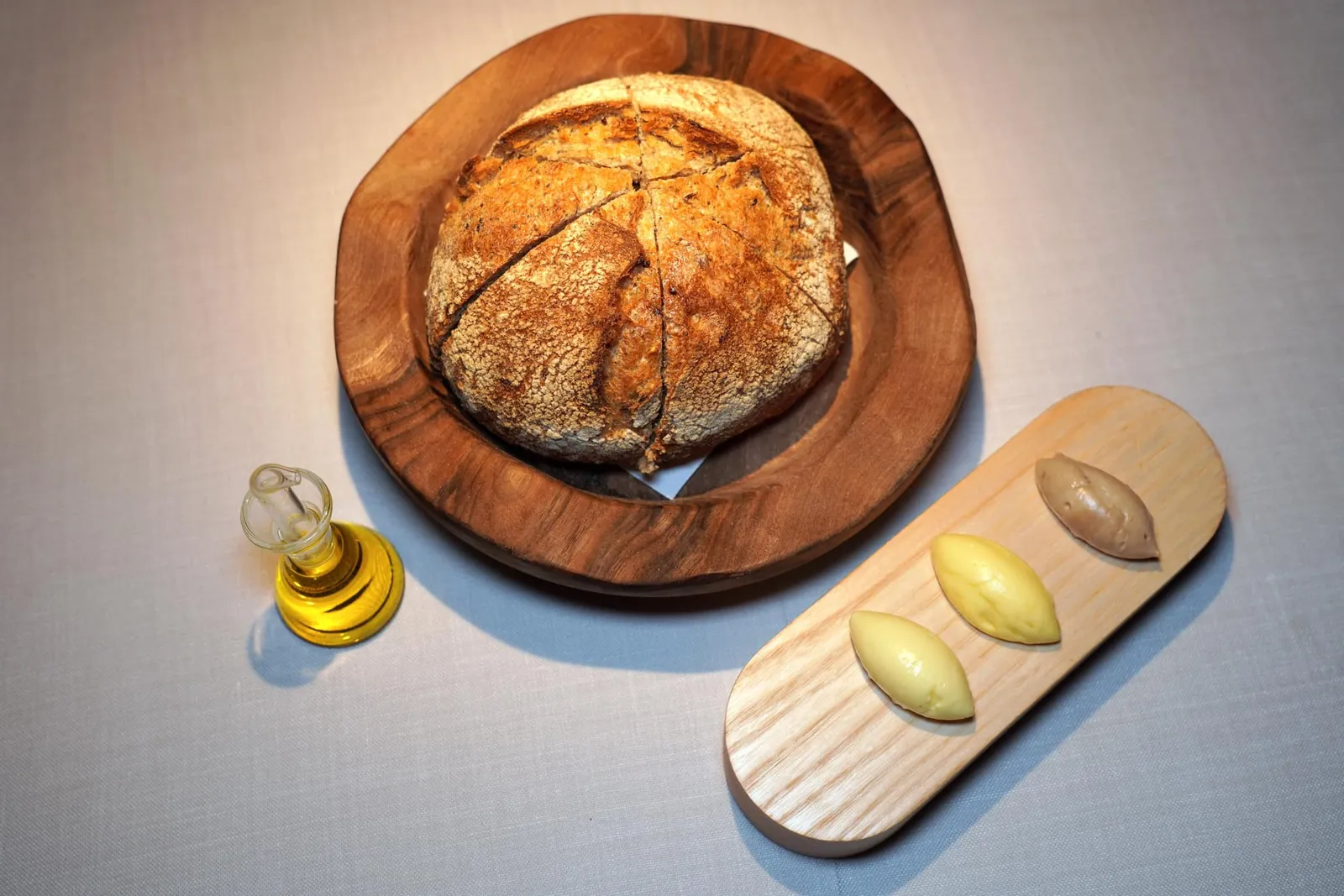 Poppy seed and pumpkin seed bread จากนั้นพนักงานจะเสิร์ฟขนมปังเมล็ดธัญพืชมาคู่กับเนย 3 อย่างคือ French Butter, Smoked Butter และ Toasted Butter นอกจากนี้ยังมีน้ำมันมะกอก EVO อีกด้วย
