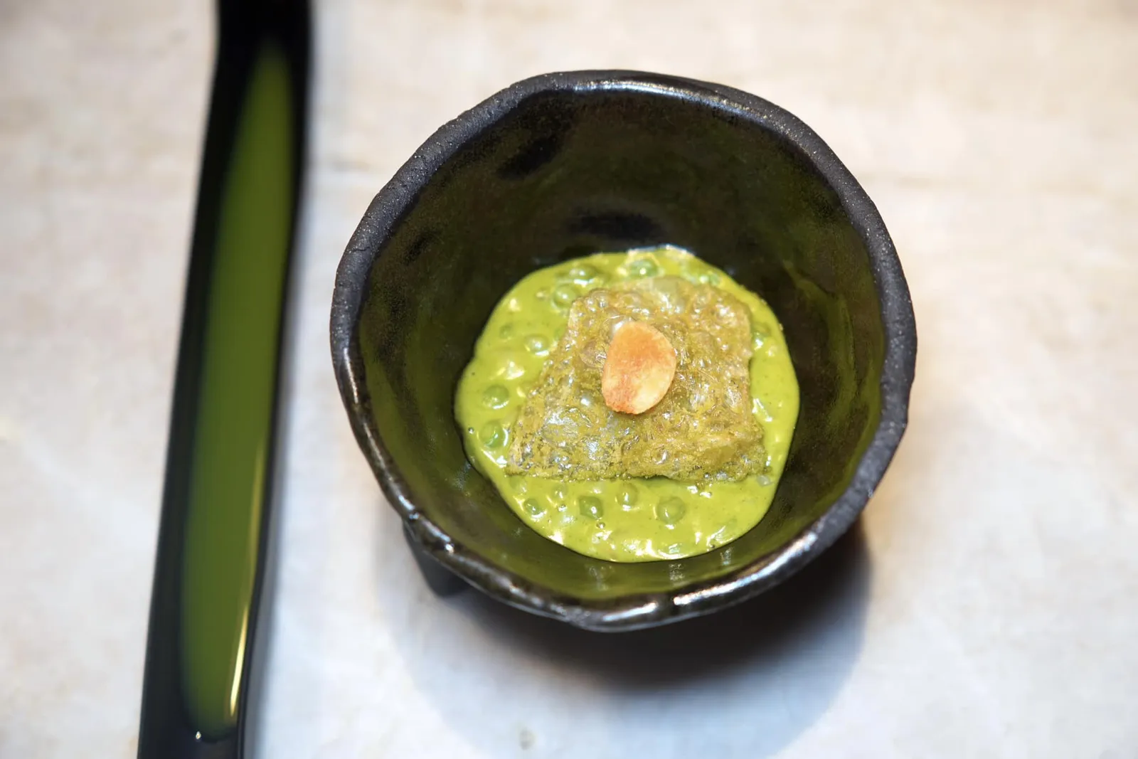 Peas • Wasabi • Sake ถัดมาคือสตูว์ที่เตรียมมาจากสายพันธุ์ถั่วลูกไก่ที่ได้รับความนิยมมากในประเทศสเปนอย่าง Tear Peas หรือ Guisante Lágrima จับคู่มากกับ Pil Pil Sauce ด้านบนคือแผ่นแคร็กเกอร์กรอบที่เชฟโดยการนำหนังปลาค็อดไปทอดจนฟูกรอบก่อนจะตกแต่งกลิ่นด้วยอโรมาของผงวาซาบิเล็กน้อย ข้างกันคือสาเกที่เชฟ Infused ด้วยผิวของถั่ว Guisante Lágrima จนได้ความเขียวที่ไม่ฉุนมากนักใช้ในการล้างปากก่อนเข้าสู่คอร์สถัดไป (17/20)