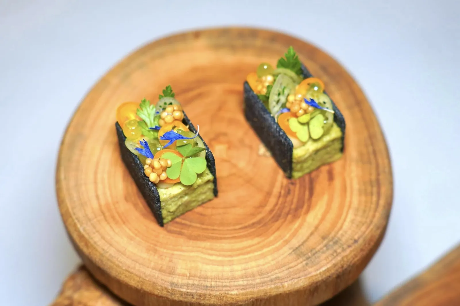 FREE RANGE CHICKENSeasonal Herbs, Yellow Chili, Mustard Seedsคำนี้เชฟได้รับแรงบันดาลใจมาจากเมนูไก่ใต้น้ำ เชฟเตรียมแผ่นแครกเกอร์มาจากข้าวคั่วและผงกระเทียมต้นย่าง ตรงกลางคือเทอร์รีนเด้งสู้ฟันได้จากการนำไก่ไปผ่านการ Slow-cooked ก่อนจะผสมผสานกับมูสสมุนไพรอีสานจนหอมกรุ่น เชฟเติมแต่งด้วยสายบัวสด พริกเหลือง และเมล็ดมัสตาร์ดดอง (15/20)