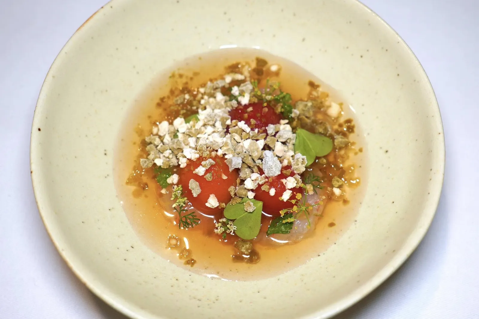 LANGOUSTINEChiang Mai Tomatoes, Roasted Shallot, Green Chiliเชฟอาศัยแนวคิดของเมนูน้ำพริกมะเขือเทศและกุ้งแช่น้ำปลามาผสานเข้าด้วยกันโดยการนำกุ้ง Langoustine จากประเทศฝรั่งเศสที่เชฟนำไปหมักกับผิวมะนาว เลมอน จากนั้นรมควันต่ออีกทีหนึ่งให้รสชาติหวานโดยธรรมชาติ ยังมีมะเขือเทศ 3 สายพันธุ์จากจังหวัดเชียงใหม่ดองกับน้ำดองสมุนไพร ด้านล่างคือน้ำพริกที่ผสมผสานมะเขือเทศย่าง หัวหอมย่าง และสมุนไพรย่างเข้าด้วยกัน ส่วนซุปเย็นใส ๆ คือ Consommé ที่เตรียมมาจากมะเขือเทศสดและสมุนไพรสดให้รสชาติอูมามิ สุดท้ายคือ Snow ที่เตรียมมาจากน้ำปลาเคี่ยว พริกชี้ฟ้าเขียว และสมุนไพร (15/20)