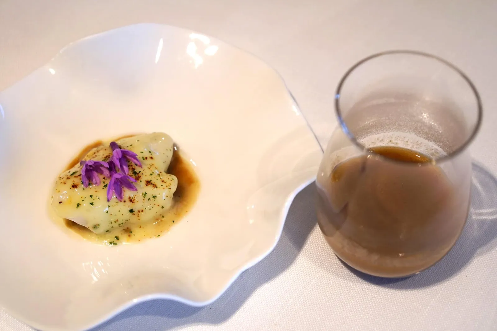 Cod “KOKOTXA”, flower and garlic soup หากให้เรานึกถึงอาหารพื้นเมืองของภูมิภาค Basque Country ซึ่งเป็นที่นิยมและมีชื่อเสียงโด่งดังไปทั่วโลกมาหนึ่งจาน บอกเลยว่าต้องยกให้กับ Kokotxa (Cococha) Al Pil-Pil หรือโคคอทช่า อัล ปิลปิล เป็นสตูว์พื้นบ้านที่ทำมากจากส่วน “คางของปลาค็อดหรือปลาเฮก” ทานกับซอสปิลปิล เป็นซอสเขียวพื้นเมืองที่มีความหนึบ และหนืดจากเจลาตินที่ได้จากกระดูกอ่อนของปลา เคลือบไปบนเนื้อคางของปลาค็อดอีกทีหนึ่ง แต่วำหรับเวอร์ชั่นของ Azurmendi แน่นอนว่าต้องนำอาหารพื้นเมืองที่เป็นความภาคภูมิใจของชาว Basque Country มายกระดับให้อร่อยเลิศขึ้นไปอีกหลายเท่าตัว