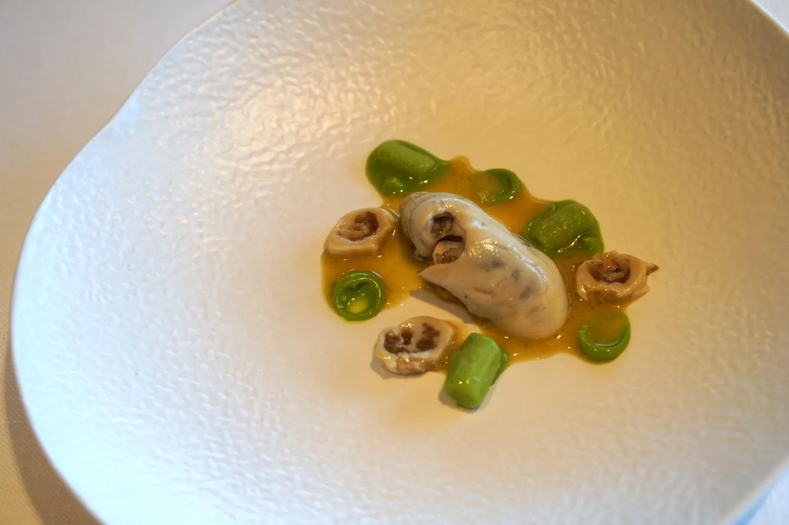 OYSTER, olive and olive oil จานถัดมาเชฟตั้งใจให้รสชาติของทะเลกระเเทกเข้ามาที่ต่อมรับรสของคนทาน พอดีกับช่วงที่เราไปเป็นช่วงที่หอยนางรมคุณภาพดีที่สุด เชฟจึงเลือกเสิร์ฟเป็น Oyster in two services ตามคอนเซป West and East โดย First service เป็น Natural Oyster หรือหอยนางรมสด เชฟนำไปลวก (blanch) ในน้ำร้อนเภียงระยะเวลาไม่ถึงหนึ่งนาที จากนั้นนำมากแช่ในน้ำเย็นเพื่อให้เนื้อหอยคงความเด้งสู้ฟัน ซึ่งเป็นลักษณะที่ดีของหอยนางรม ข้างๆกันคือหอยนางรมหั่นเเว่น ตัวหอยทำออกมาดีมากจริงๆ ไร้ซึ่งกลิ่นคาว เนื้อสัมผัสนุ่มเด้ง ทานคู่กับ Olive and olive oil in defferent textures มีทั้งซอร์เบท์เเละพูเรน้ำมันมะกอก ของเหลวด้านล่างทำจากลูกมะกอกและน้ำมันมะกอกเข้ากันได้กับหอยนางรมสดๆได้อย่างเพอร์เฟค (19/20)