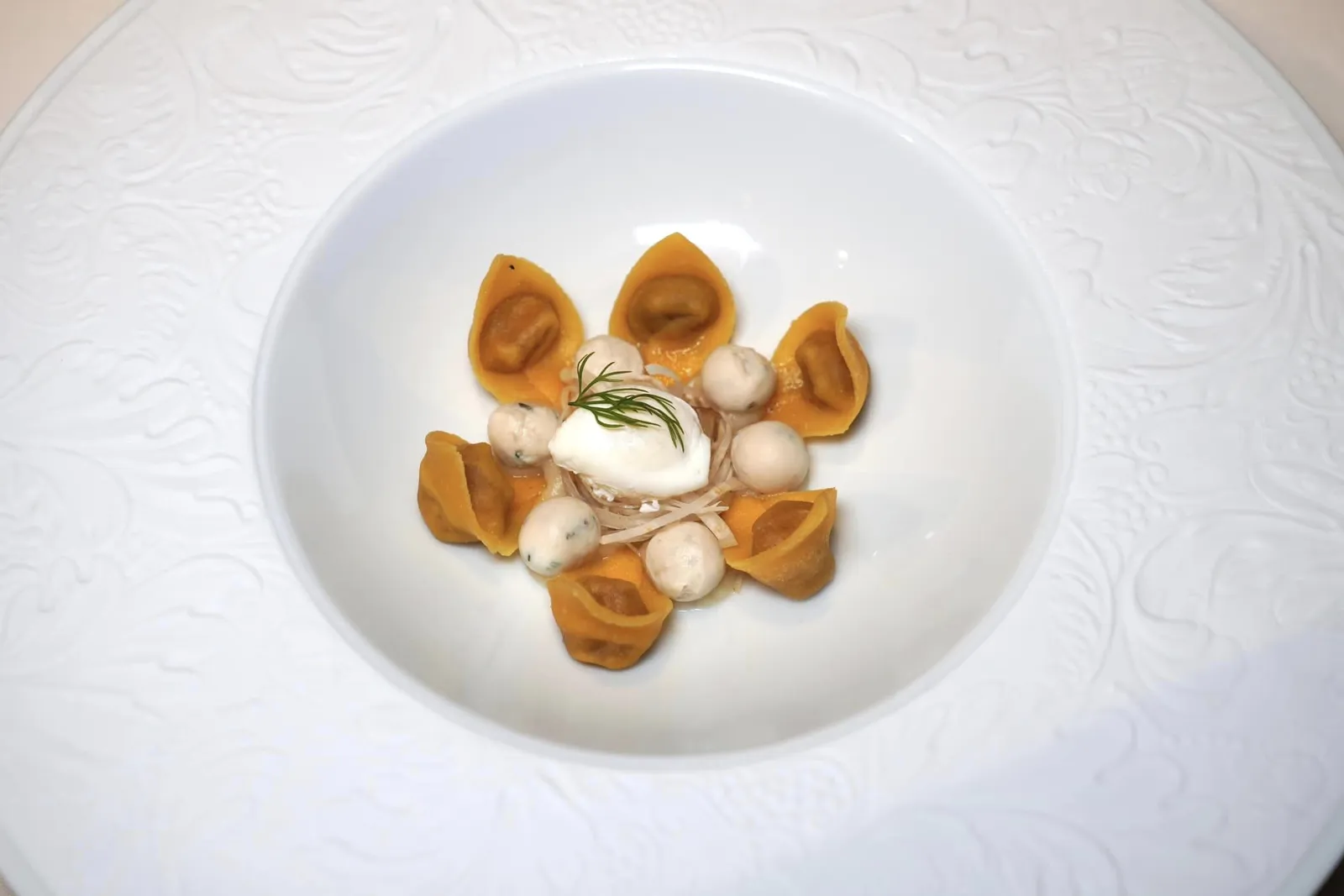 Cappelletti Fresh Pasta • Black Rooster • Broth • Celeriac พาสต้าเส้นสด Cappelletti มีรูปร่างเป็นเกี๊ยววงแหวนคล้ายหมวก ด้านในสอดไส้เนื้อส่วนอกและขาของไก่ดำให้รสชาติเค็มนำ รอบ ๆ คือลูกชิ้นที่เตรียมมาจากอกไก่ดำและแป้งคลุกเคล้าเข้าด้วยกันให้เนื้อสัมผัสค่อนข้างนุ่ม ตรงกลางคือไข่ที่พร้อมจะแตกเยิ้มออกมาทันทีที่ใช้ช้อนหรือมีดตัดเพียงเบา ๆ รองด้านล่างด้วย Celeriac อีกทีหนึ่ง (18/20)
