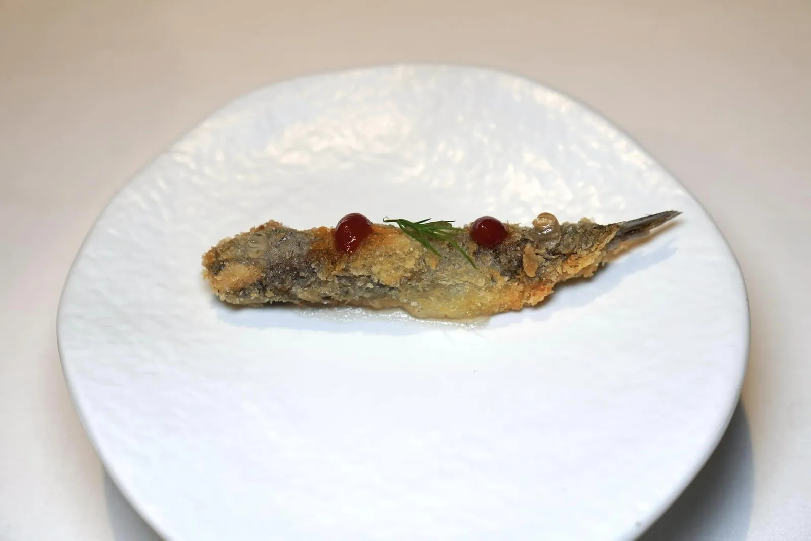 Amuse-bouche ปลาแองโชวี่ทอดออกมาได้อย่างไร้ที่ติเสริมด้วยรสชาติเปรี้ยวจากเพสต์เลมอน ด้านบนท็อปด้วยครีมมะเขือเทศและเจลของน้ำส้มสายชู (18/20)