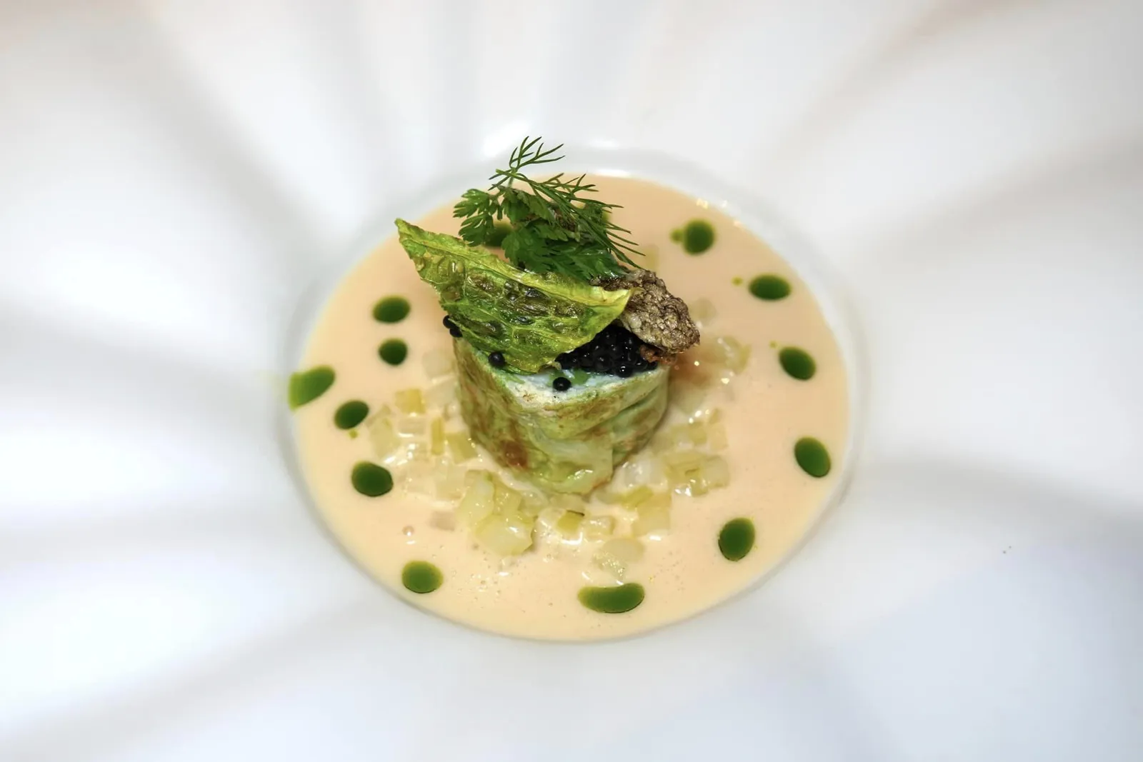 Sole • Savoy Cabbage • Herring Caviar จานนี้เชฟนำปลาโซลมาพันม้วนด้วยกะหล่ำปลีซาวอยและนึ่งจนสุกเพื่อให้ได้เนื้อสัมผัสที่มีมิติความกรอบของผักที่ชั้นนอกในขณะที่ตรงกลางมีความนุ่มละมุนของเนื้อปลา รอบ ๆ คือซอส Acid-Butter Reduction ที่ผ่านการเคี้ยวจนงวดให้รสเปรี้ยวนำ ด้านบนท็อปด้วยไข่ปลาเฮร์ริงและหนังปลาโซลทอดกรอบนั่นเอง (17/20)