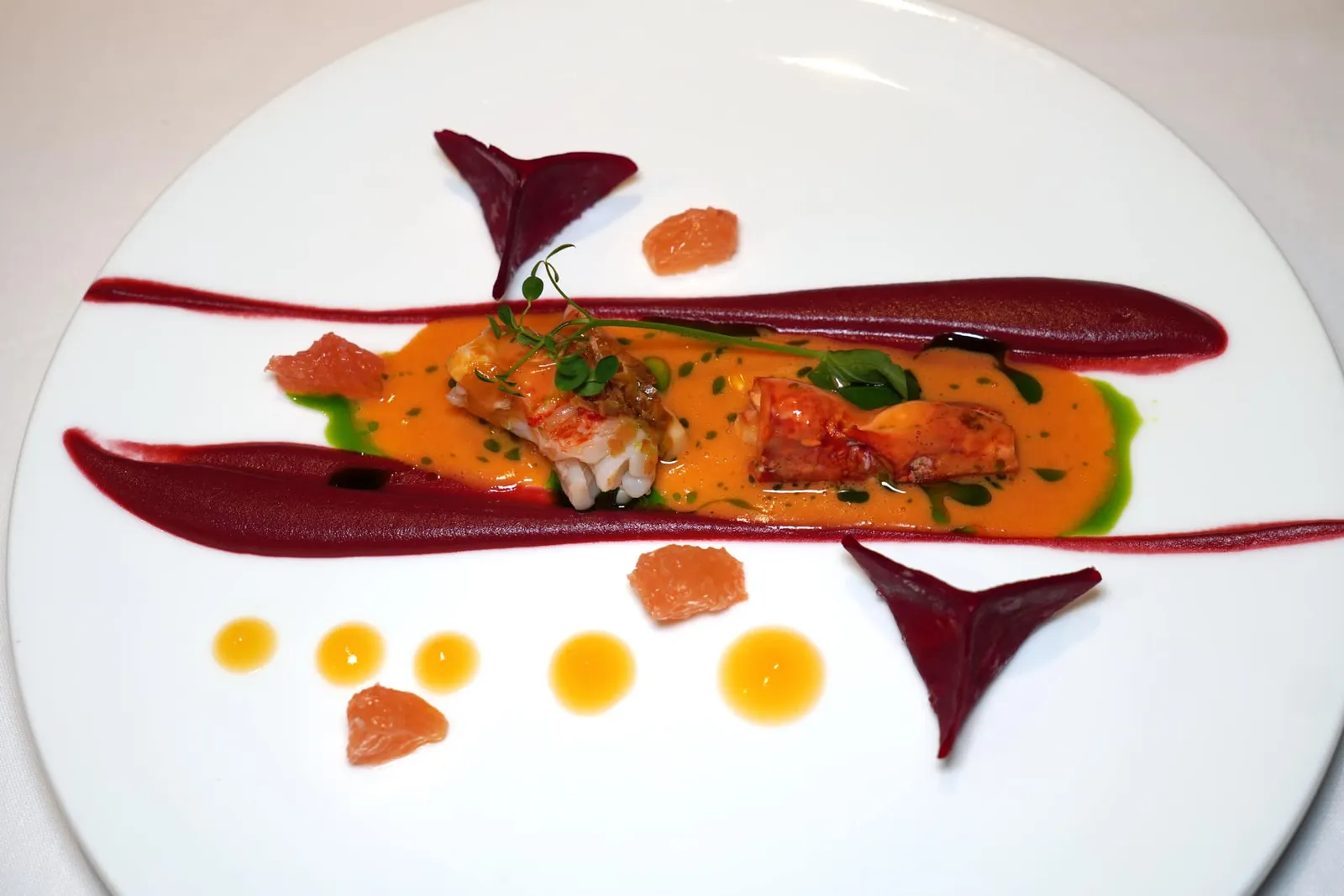 Blue Lobster • Beetroot • Chives • Grapefruit กุ้งบลูล็อบสเตอร์นุ่มเด้งเสิร์ฟมากับซอสบิสก์เข้มข้นตัดด้วยความฉุนเบา ๆ ของน้ำมันต้นหอม เชฟจับคู่รสชาติกับครีมบีทรูทที่มี Earthy Aroma พอเหมาะไม่หนักจนเกินไป ข้าง ๆ กันคือชิ้นเกรปฟรุต ยังมีราวิโอลีที่เตรียมมาจากบีทรูท ตรงกลางสอดไส้ล็อบสเตอร์ ต้นหอม และผลไม้จำพวก Red Fruits ให้รสชาติออกเปรี้ยวมาตัดกันกับความมันของซอสบิสก์และความหวานของเนื้อล็อบสเตอร์ได้อย่างลงตัว (19/20)