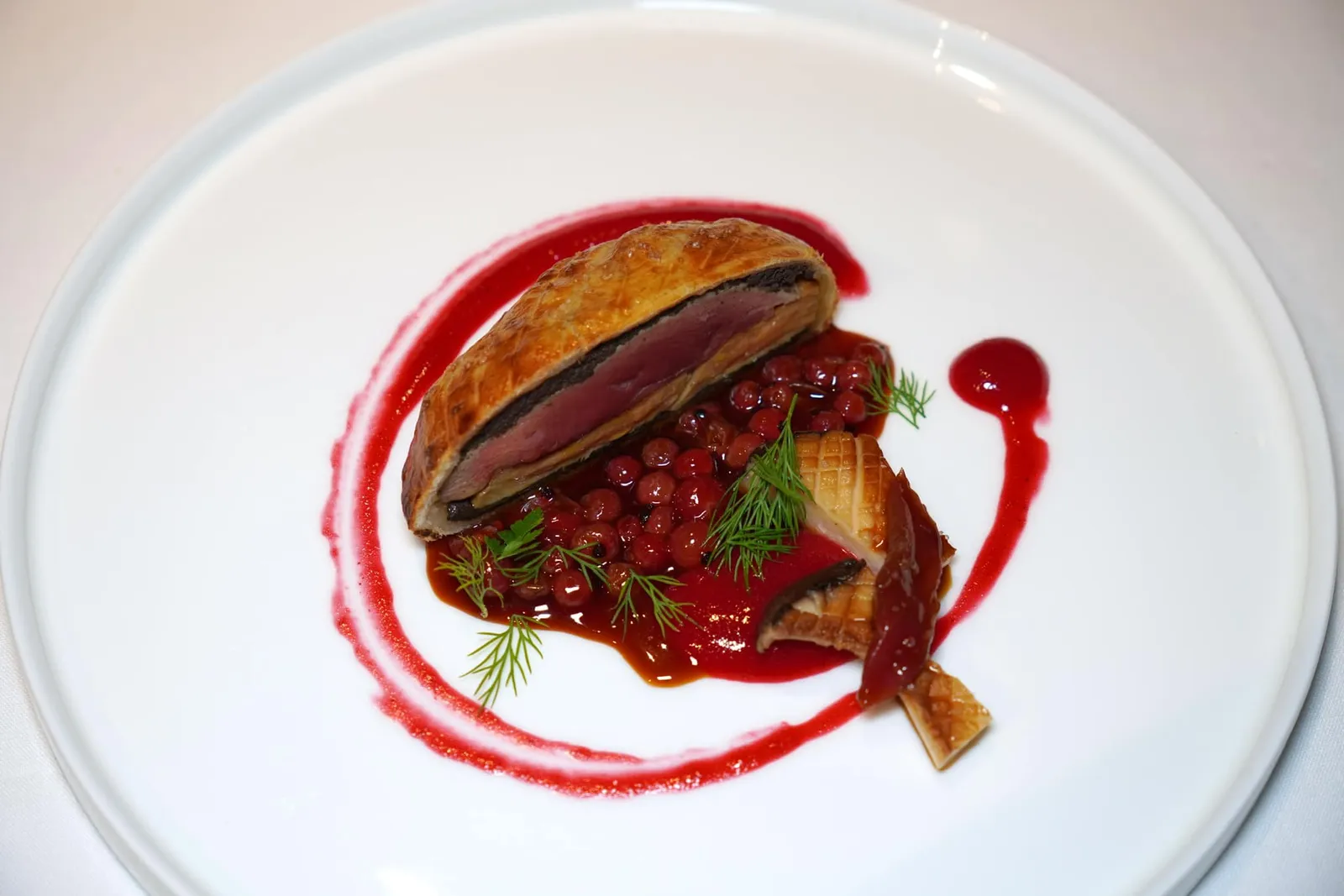 Pigeon in Crust • Cardoncello Mushroom • Foie Gras • Cranberry นกพิราบที่คัดส่วนอกเสิร์ฟมาในแป้งพัฟแพสทรี่ เนื้ออกของนกยังคงไว้ซึ่งความฉ่ำ ชั้นตรงกลางคือที่สับจนละเอียด นอกจากนี้ยังมีชั้นของฟัวกราส์ให้ความครีมมี่และละมุน รอบ ๆ คือซอสสีแดงที่เกิดจากการ Reduction เนื้อส่วนปีกและอกของนกพิราบจนงวดและมีรสชาติเข้มข้นผสมผสานไปกับความเปรี้ยวของแครนเบอร์รี่ (20/20)