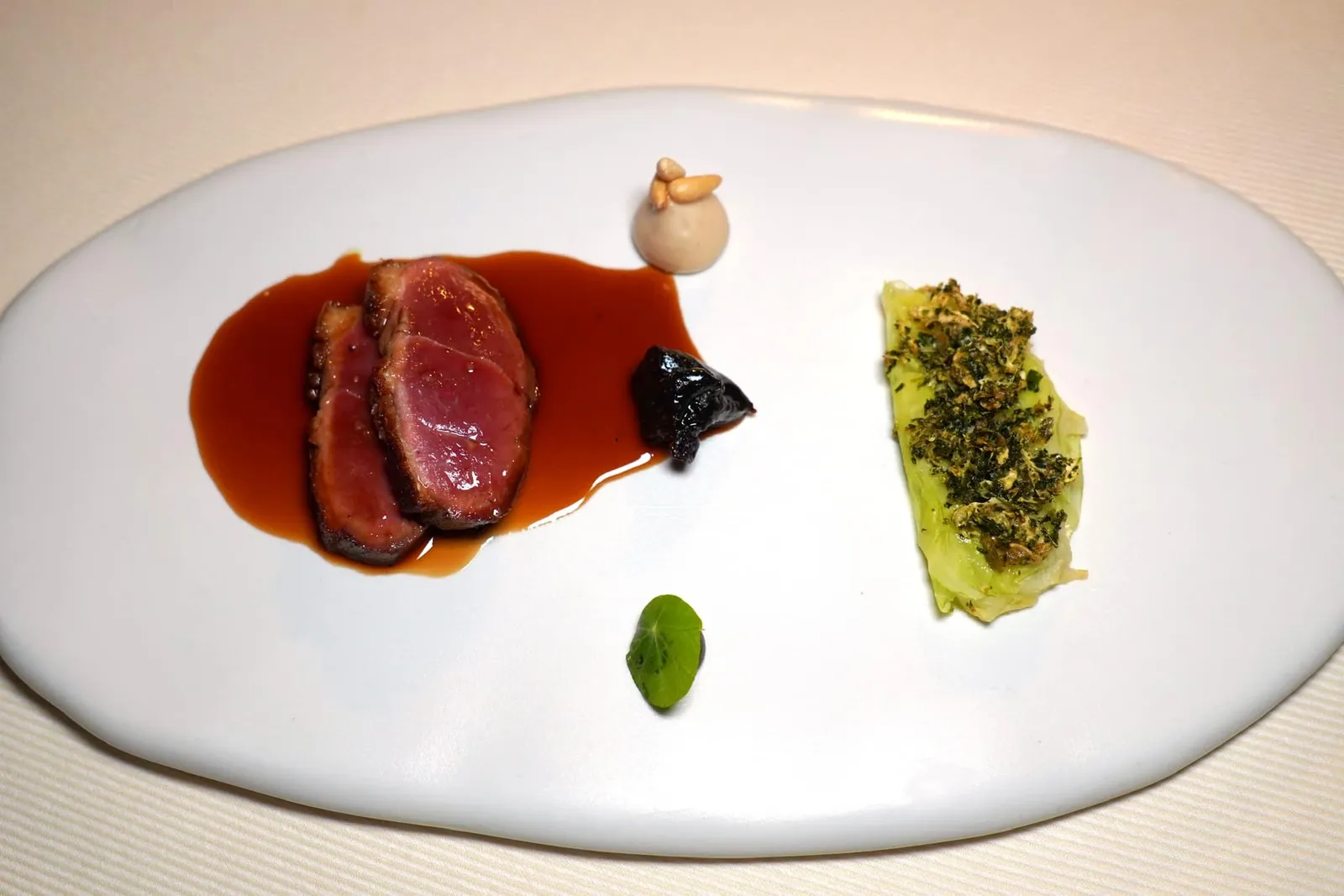 Duck Duck breast, cabbage, plum and hoisin sauce เนื้อเป็ดส่วนอกเสิร์ฟมากับองค์ประกอบของซอสฮอยซินและซอสบ๊วยให้กลิ่นอายของความเป็นเอเชีย ในจานยังมีกะหล่ำปลีและกะหล่ำปลีดำ จากนั้นพนักงานจะเทราด Duck Jus ลงไปนั่นเอง (15/20)