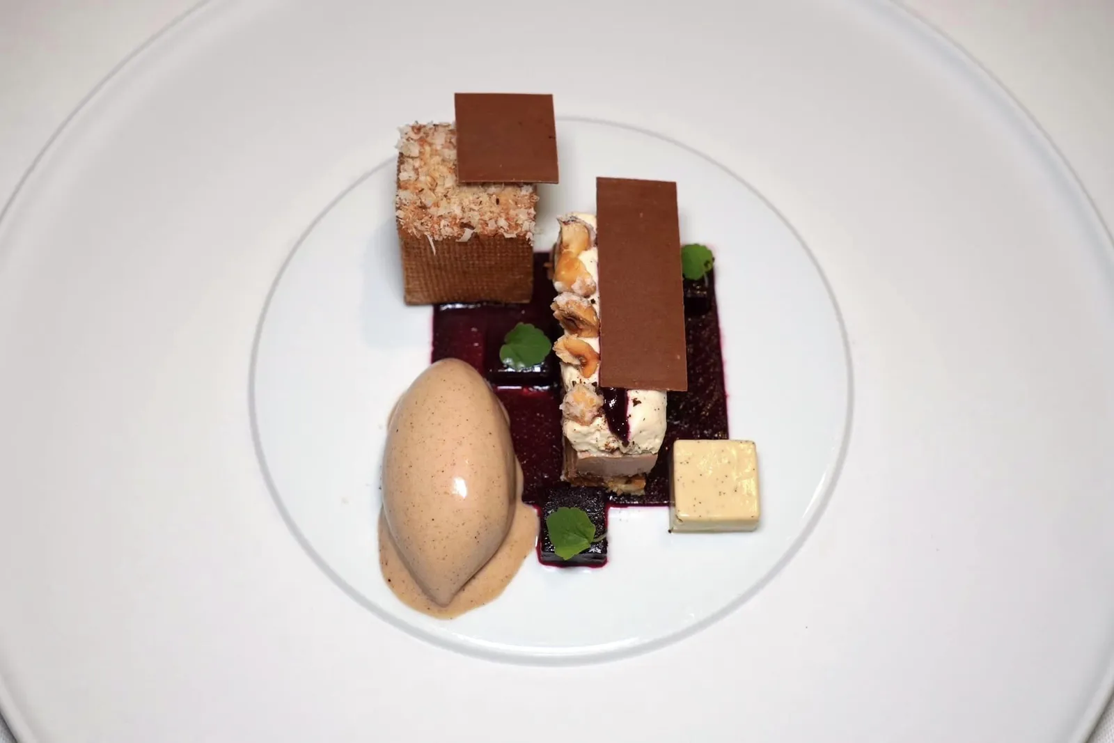 HAZELNUT HAZELNUT - BLACKCURRANT - TOASTED VANILLA จานนี้เชฟนำเสนอถั่วฮาเซลนัทจากแคว้น Piedmonte ประเทศอิตาลีนำเสนอมาในหลากหลายองค์ประกอบทั้ง Sorbet, Crocanti, Ganache ผสมผสานกับวานิลลาคั่ว และเจลลี่ (20/20)