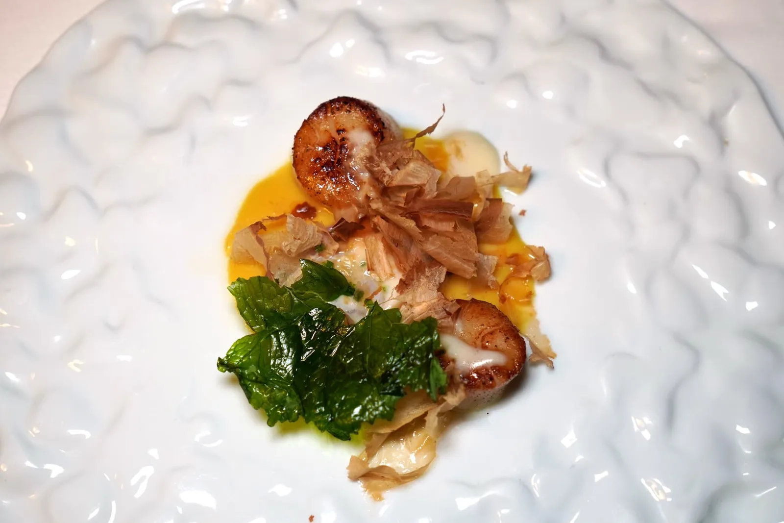 Capasanta arrostita, dentice in ceviche, laksa di cocco e bagna cauda คอร์สนี้คือหอยเชลล์ย่างสไตล์บาร์บีคิวเนื้อนุ่มหวาน ข้างกันคือปลา Dentice หรือ Red Snapper เสิร์ฟมาในสไตล์ Ceviche เพื่อให้ความซิตรัสมาตัดกันกับความครีมมี่ของซอง Coconut Laksa จานนี้จบด้วยการขูด Katsuobushi ลงไปให้เนื้อสัมผัสเฉพาะตัวและองค์ประกอบของ Cime de Rapa ในลักษณะขอวแผ่นชิปส์กรอบ ๆ จานนี้เชฟตั้งใจนำเสนอวัตถุดิบและกลิ่นอายของอาหารฝั่งเอเชียผสมผสานกับวัตถุดิบท้อวภิ่นของฝั่งอิตาลีนั่นเอง (14/20)