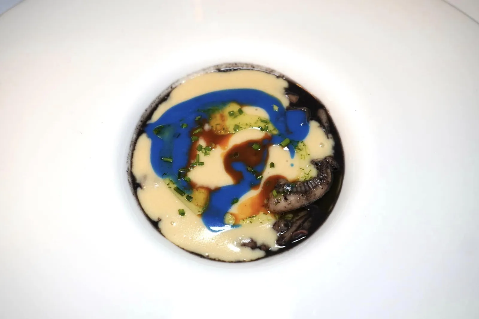 Cappuccino di patate, seppia al nero e ricci di mare Cappuccino di Patate มีลักษณะเป็นซุปที่เตรียมมาจากหมึกกระดองหรือ Cuttlefish ด้านบนท็อปด้วยครีมมันฝรั่งเนื้อเนียนสีเหลืองอ่อน อวค์ประกอบของดีหมึกสีดำ จากนั้นเติมแต่งสีสันอันหลากหลายทั้ง Sea Lettuce, หอยเม่น, Coriander ส่วนโปรตีนหลักของจานคือหนวดหมึก จานนี้จบด้วยการเทราด Aromatic Olive Oil ลงไปด้านบน โดยรวมถือเป็นจานที่มีมิติและหลากหลายแต่อาจยังไม่ดีเท่าห้องอาหารต้นตำรับผู้คิดค้นจานนี้อย่าง La Calandre (15/20)