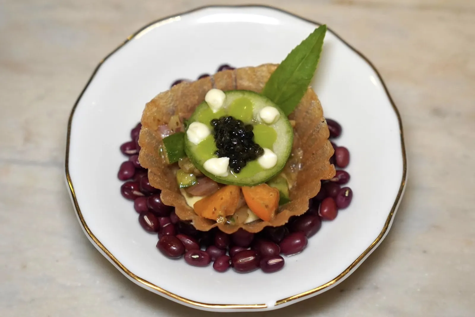 YELLOWTAIL TARTARERice paper tartlet, yellowtail, rice paddy herbเริ่มต้นมื้ออาหารด้วยแผ่นข้าวเกรียบกรอบ ตรงกลางบรรจุเนื้อปลา Yellow Tail นุ่ม ๆ เชฟปรุงแต่งกลิ่นด้วย Ngò Ôm ซึ่งเป็นสมุนไพรที่พบได้ทั่วไปให้รสชาติเปรี้ยวคล้ายเลมอนและอโรมาคล้ายใบยี่หร่า ทั้งยังเป็นสมุนไพรที่นิยมใช้ใส่ในซุปอาหารทะเลของอาหารเวียดนามตอนใต้อีกด้วย ยังมีโกลเด้นเบอร์รี่และแตงกวาช่วยเรียกความสดชื่น ทุกองค์ประกอบผสานเข้าด้วยกันจากการใส่ครีมผักชีลาวและซาวครีม (14/20)
