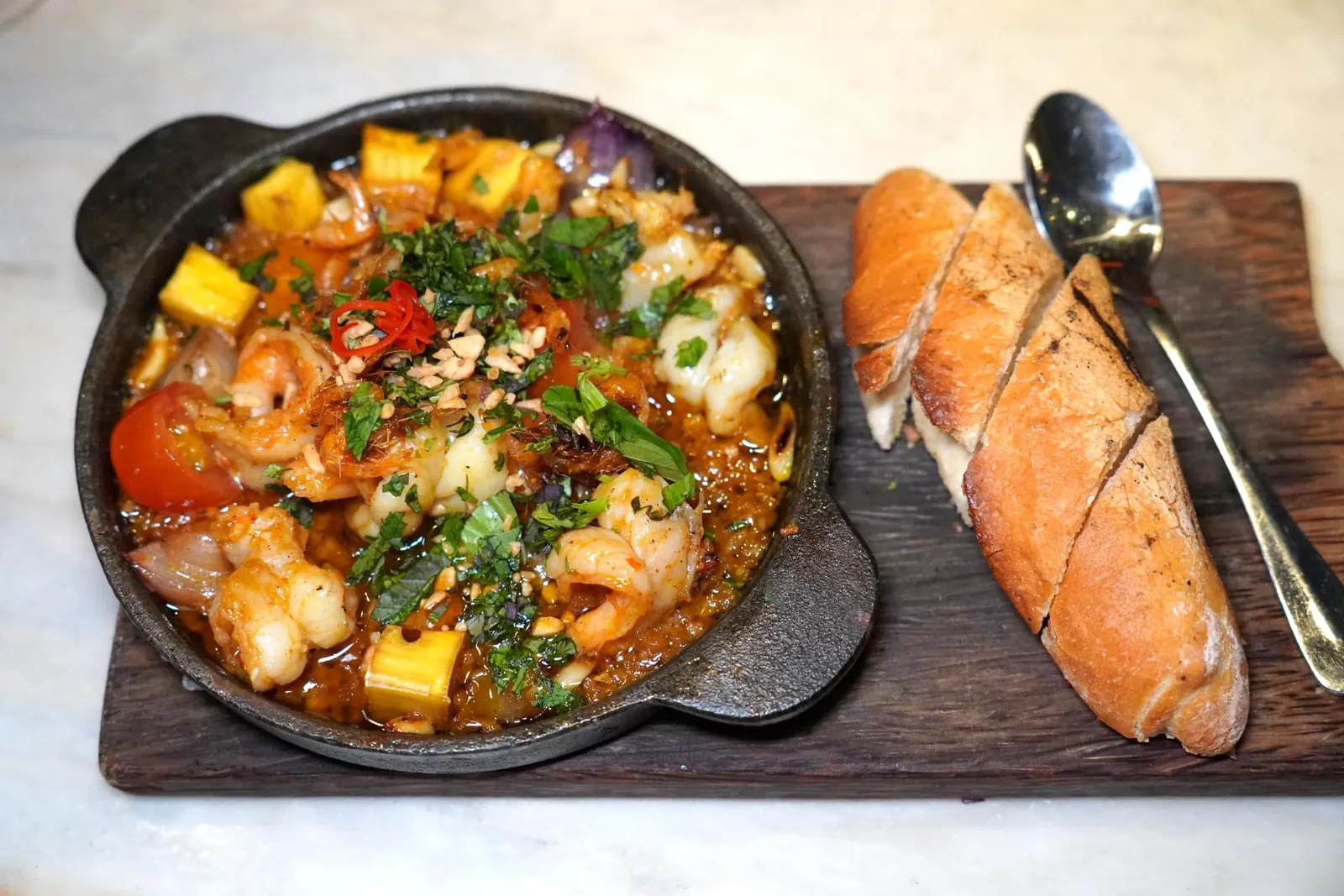 BUTTER GARLIC PRAWN (230,000 VND++)Butter garlic sauce, grilled banh miจานนี้คือเมนูแบบ À La Carte ที่เราได้ลองสั่งมาชิมกันดูมีบักษณะเป็นกุ้งเสอร์ฟมากับซอสเนยกระเทียมในกระทะร้อน ตัวซอสมีองค์ประกอบที่หลากหลายทั้งมันหวานและมะเขือเทศทำให้มีรสชาติอร่อยได้โดยไม่ต้องตีความ ข้างกันคือขนมปัง Buhn Mi สำหรับรับประทานคู่กัน (14/20)
