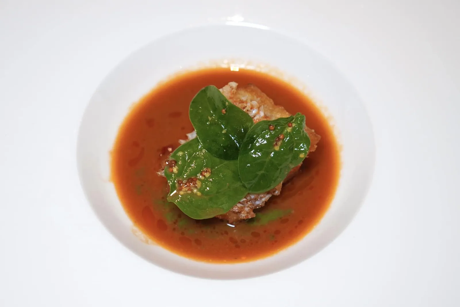 Steamed and then fried scorpionfish fillet with “cacciucco” broth, swiss chard with mustard and braised tomato oilปลา Scorpionfish ที่ผ่านกระบวนการนึ่งแล้วทอดต่อจนได้เนื้อสัมผัสที่สู้ฟันตามธรรมชาติของปลาชนิดนี้แต่กลับไร้ซึ่งความเหนียว เชฟเสิร์ฟมาคู่กันกับ Cacciucco ซึ่งเป็นเมนูจำพวกสตูว์ปลาท้องถิ่นจากเมืองชายทะเลฝั่งตะวันตกของแคว้น Tuscany ด้านบนทอปด้วยใบ Swiss Chard และเมล็ดมัสตาร์ด นอกจากนี้เชฟยังใส่น้ำมันมะเขือเทศลงไปให้ความอุมามิอีกด้วย (18/20)