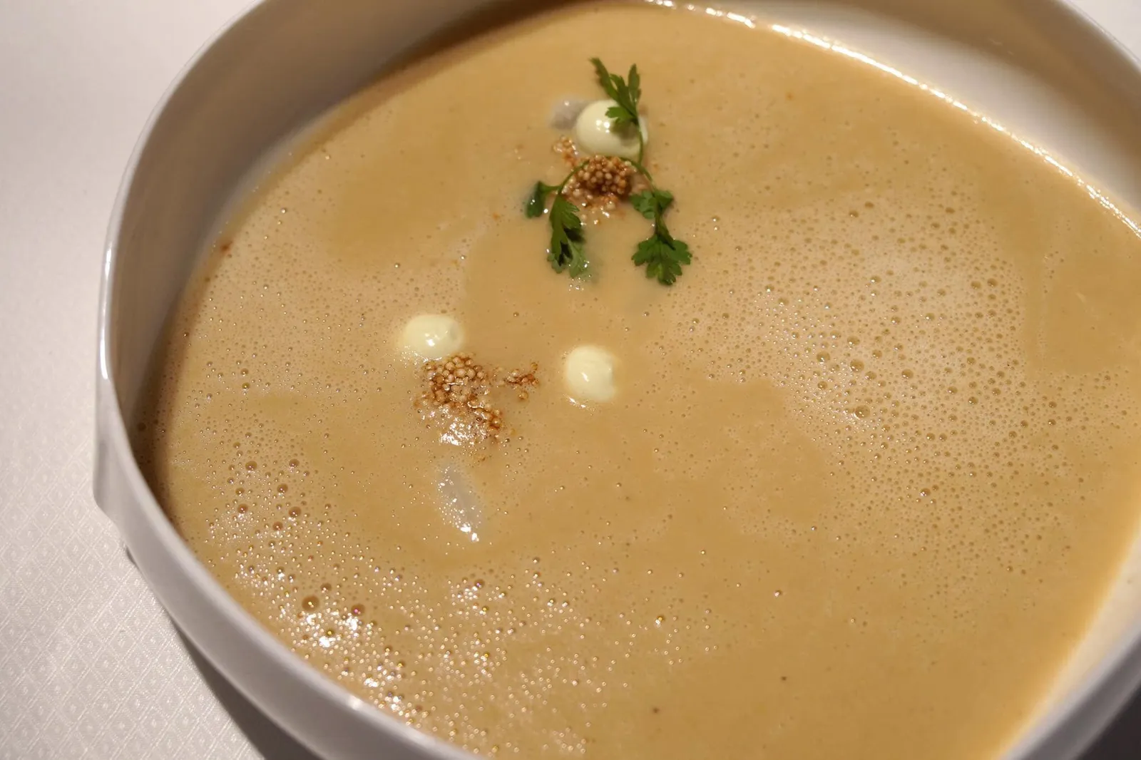 - Spargelsuppe (6 EUR)Schaumsuppe von niederbayrischem weißem Spargel mit Bärlauchtopfen & Getreide🥬 ณ ช่วงเวลาที่เรามาเป็นช่วงที่หน่อไม้ฝรั่งในยุโรปมีรสชาติดีที่สุดในรอบปีพอดี จานถัดมาเราจึงเลือกชิมเป็นซุปโฟมหน่อไม้ฝรั่งขาวจากตอนล่างของแคว้นบาวาเรีย ทานกับซีเรียล และแรมสันหรืออีกชื่อคือกระเทียมป่า ตัวซุปโฟมมีความบางเบามากๆ มีกลิ่นหอมเข้ากันได้ดีกับกระเทียม มีรสชาติหวานอมเปรี้ยวที่เป็นเอกลักษณ์ของหน่อไม้ฝรั่งขาว ลงตัวสุดๆ
