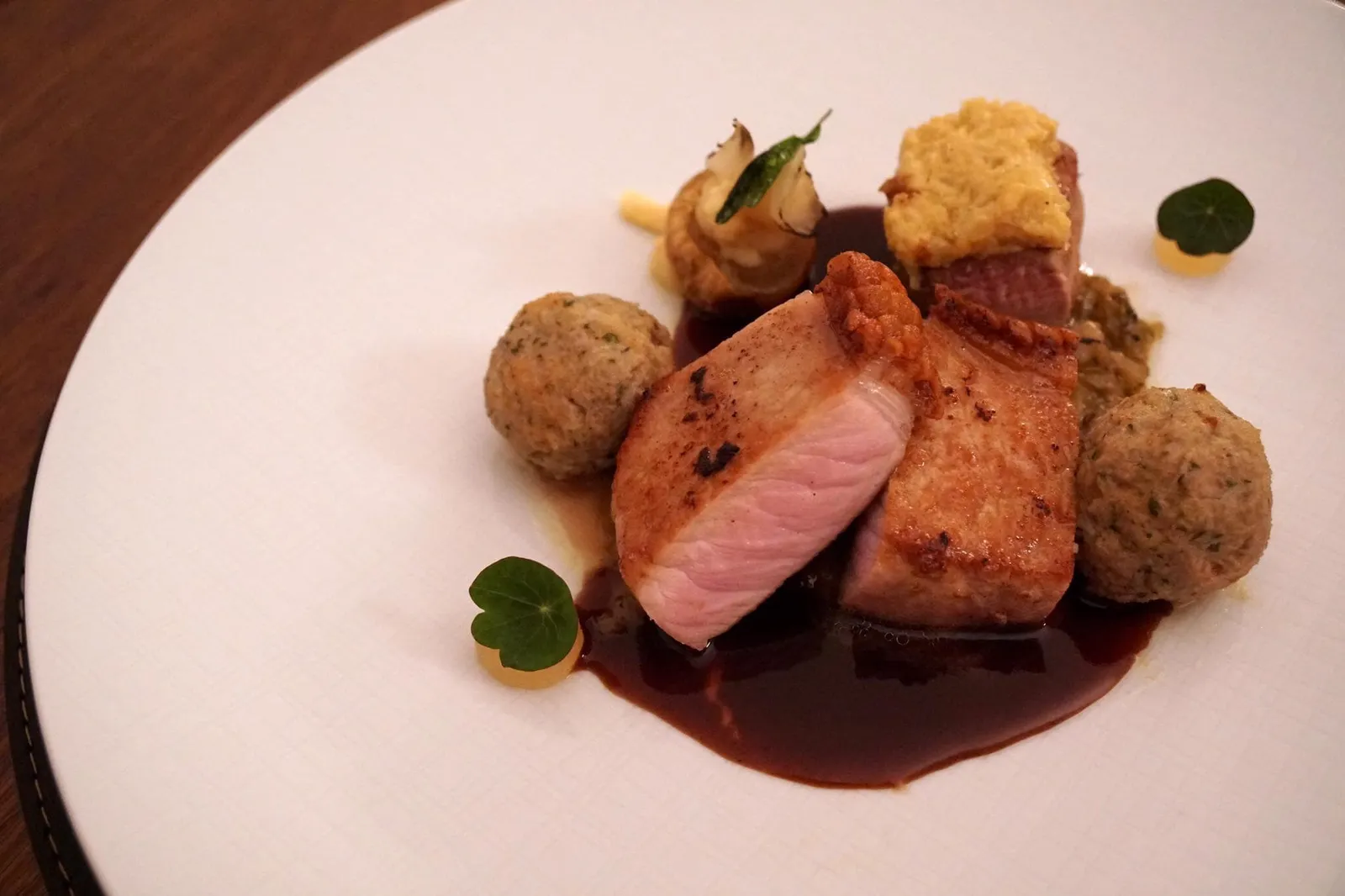- “Roast Pork with a Difference” (34.90 EUR)back of duroc pork / Bavarian herb / melted dumplingส่วนหลังของหมูดูร็อค นำไปย่างจนหนังกรอบ เเต่เนื้อข้างในยังฉ่ำนุ่ม จานนี้ต้องบอกเลยว่าโดดเด่นเเละอร่อยมาก ดีกว่าหมูดำคุโรบุตะเสียอีก ราดด้วยน้ำซอสรสเข้มข้น ทานกับเกี๊ยวที่รสชาติเหมือนลูกชิ้นหมู และสมุนไพรท้องถิ่นของเเคว้นบาวาเรีย