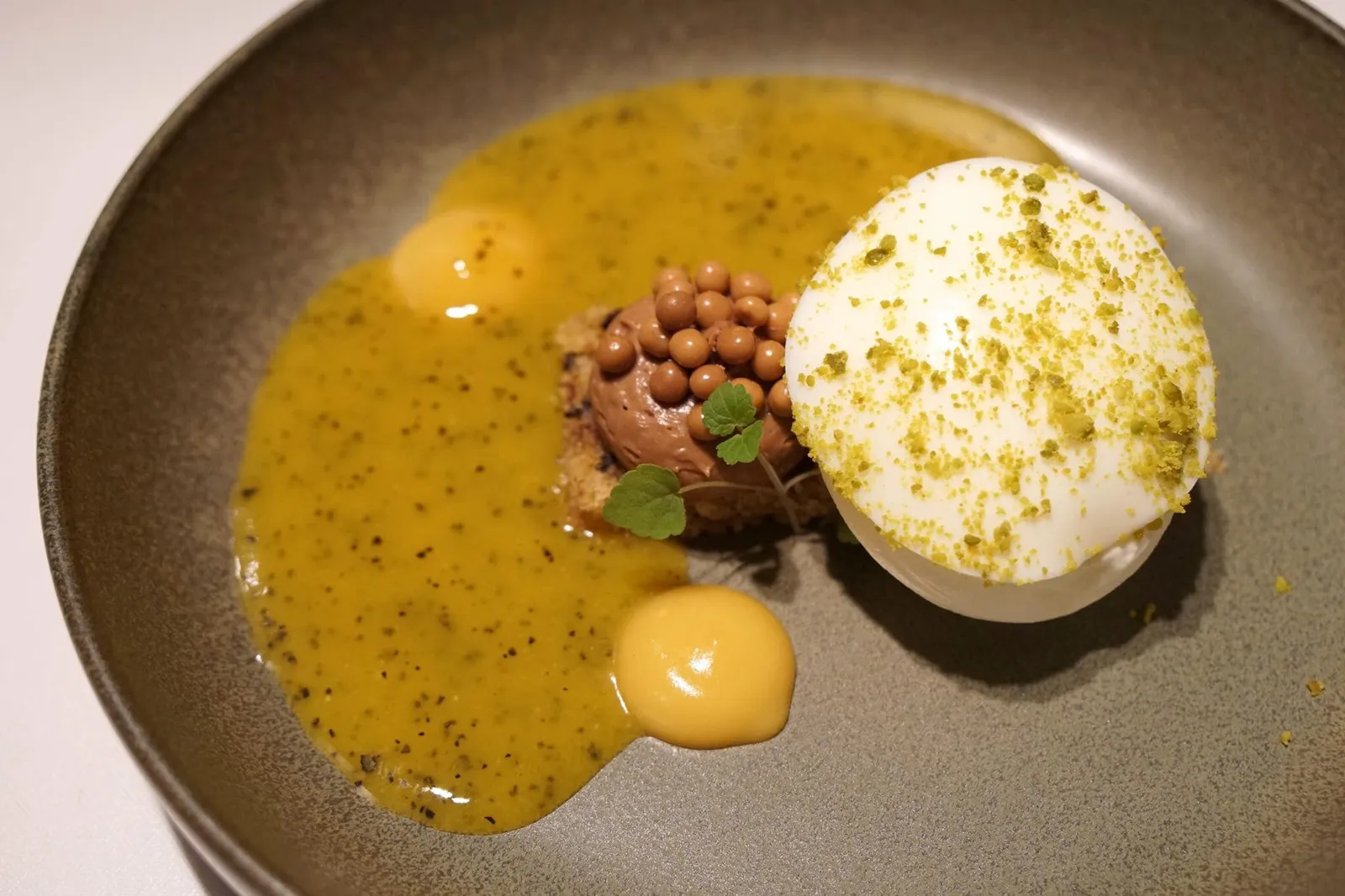 - Schokobanane (12 EUR)Bananen Panna Cotta mit weißer Schokolade, Maracuja & Toblerone Softeisอย่างแรกคือไวท์ช็อกโกแลต ราดด้วยซอสเสาวรสรสเปรี้ยว เจลเสาวรส และไอศกรีมทำจากขนมช็อกโกแลตโทเบอโรน ความเปรี้ยวของเสาวรสตัดกันกับรสหวานของไวท์ช็อกโกแลต ดีงามสุดๆ
