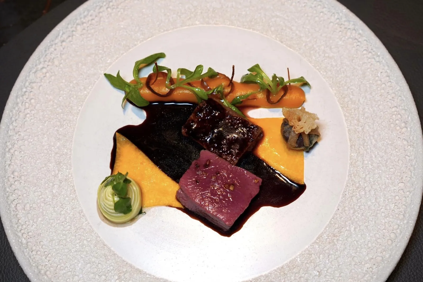 V.Eifler saddle of deer, -ragout and offal croustillant on pickled pumpkin with Vineyard field salad and rooibosjusSaddle หรือเนื้อส่วนหลังของกวางเสิร์ฟมาที่ความสุกแบบมีเดียมแรร์ให้เนื้อสัมผัสที่นุ่มละมุน ไร้ซึ่งกลิ่นสาบ เชฟจับคู่มากับฟักทองดองให้รสเปรี้ยวนำแทรกด้วยรสหวาน นอกจากนี้ยังมีครีมฟักทองท็อปด้านบนด้วยสลัดที่ใช้ผักที่เติบโตขึ้นมาในแถบไร่ไวน์ ไฮไลท์ของจานคือ Praline และ Croustillant ที่มีไส้เตรียมมาจากเครื่องในกวางและ Ragout ให้รสชาติที่เข้มข้นไร้ซึ่งกลิ่นคาวอีกเช่นกัน เชฟราดด้วยซอสที่เตรียมมาจากรอยบอสและวานิลลาลงไปเพื่อเชื่อมรสชาติของทุกองค์ประกอบให้เข้ากัน (18/20)