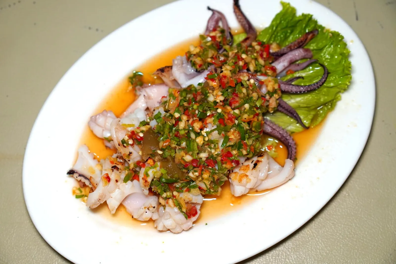 ปลาหมึกย่างมะนาว (180+)Grilled Squid with Limeปลาหมึกสด ๆ ย่างมาแบบสุกกำบังพอดีไม่เหนียว จากนั้นราดด้วยน้ำซอสรสชาติจัดจ้าน (13/20)