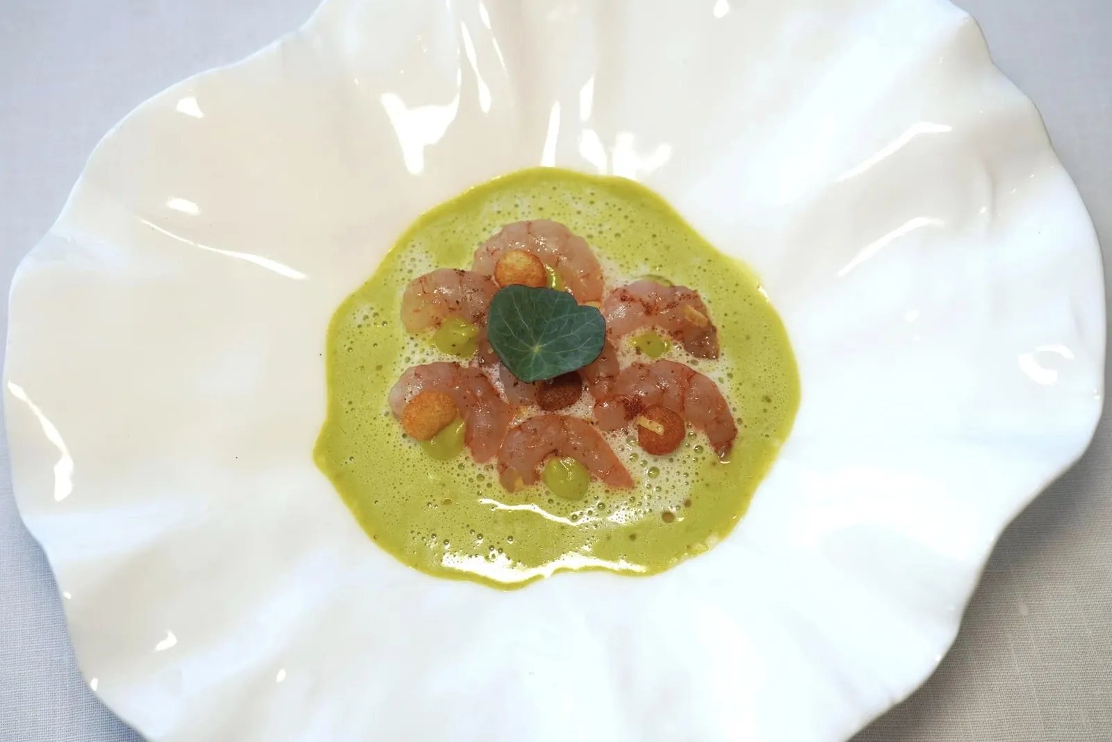 BOUQUET SHRIMP JUST COOKEDrosabelle potatoes from Juliette, nasturtium coulis of Maud and cardamon infusionLe Bouquet Breton เป็นวัตถุดิบท้องถิ่นขึ้นชื่อของแคว้น Brittany เชฟนำเนื้อกุ้งไป Confit จนให้รสชาติที่มีความหวานโดดเด่นควบคู่ไปกับเนื้อสัมผัสอันแสนนุ่มละมุน ยังมีมันฝรั่ง Rosabelle จาก Juliette เสิร์ฟมา 2 แบบทั้งส่วนที่หั่นเป็นชิ้นให้เนื้อสัมผัสที่หนึบและสู้ฟันและ Pommes Soufflées ที่มีความกรอบเบา รอบ ๆ คือซอสอีมัลชั่นสีขาวที่มีอโรมาเฉพาะตัวจาก Cardamom ผสานเข้ากันกับซอส Coulis สีเขียวที่เตรียมมาจาก Garden Nasturtium หรือ Capucine ซึ่งมีรสชาติเปรี้ยวเบา ๆ ชูความหวานของกุ้งให้โดดเด่นออกมาได้อย่างไร้ที่ติ (18/20)