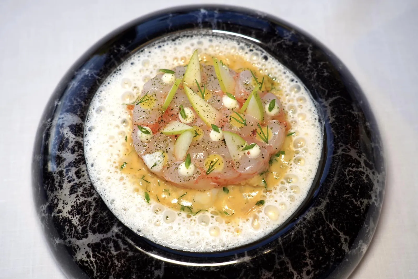 CREAMY RISOTTO WITH HADDOCKlangoustine from Brittany as a carpaccio, M. Beillevaire's parmesan emulsionข้าว Risotto ปรุงมาสุกกำลังดีคลุกเคล้ากันไปกับเนื้อปลา Haddock ด้านบนท็อปด้วยกุ้ง Langoustine เตรียมมาคล้ายกันกับ Carpaccio เนื้อนุ่มหวานฉ่ำ เชฟเพิ่มมิติทางเนื้อสัมผัสด้วยความกรอบและรสเปรี้ยวเบา ๆ ของแอปเปิ้ลเขียว Granny Smith ยังมีความเค็มและหอมของซอส Emulsion ที่เตรียมมาจากชีส Parmesan จาก Maison Beillevaire อีกด้วย (19/20)
